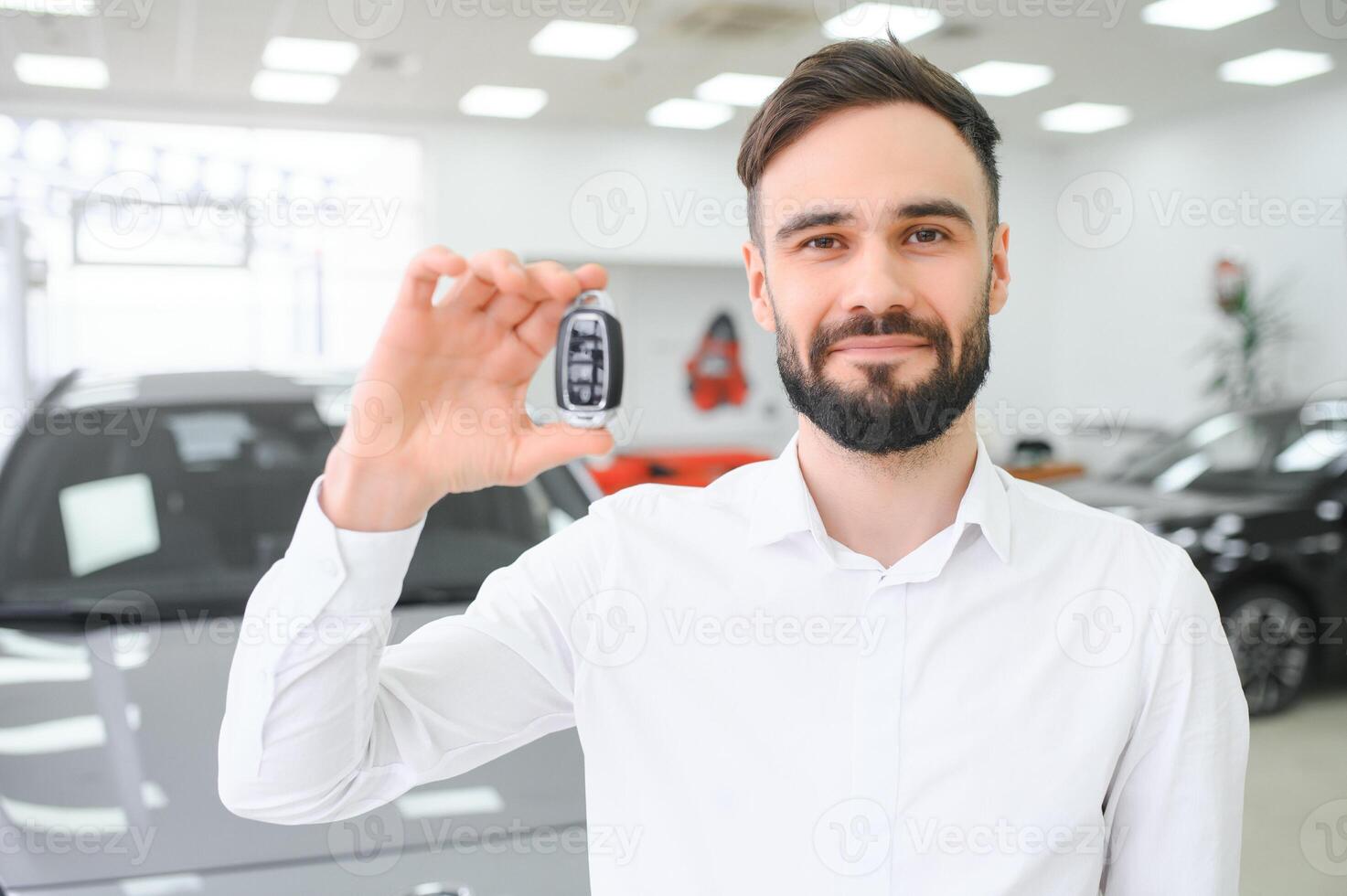 contento giovane tipo controllo nuovo lusso macchina, acquisto automobile a concessionaria centro. ritratto di allegro del Millennio caucasico uomo l'esame auto a showroom memorizzare foto