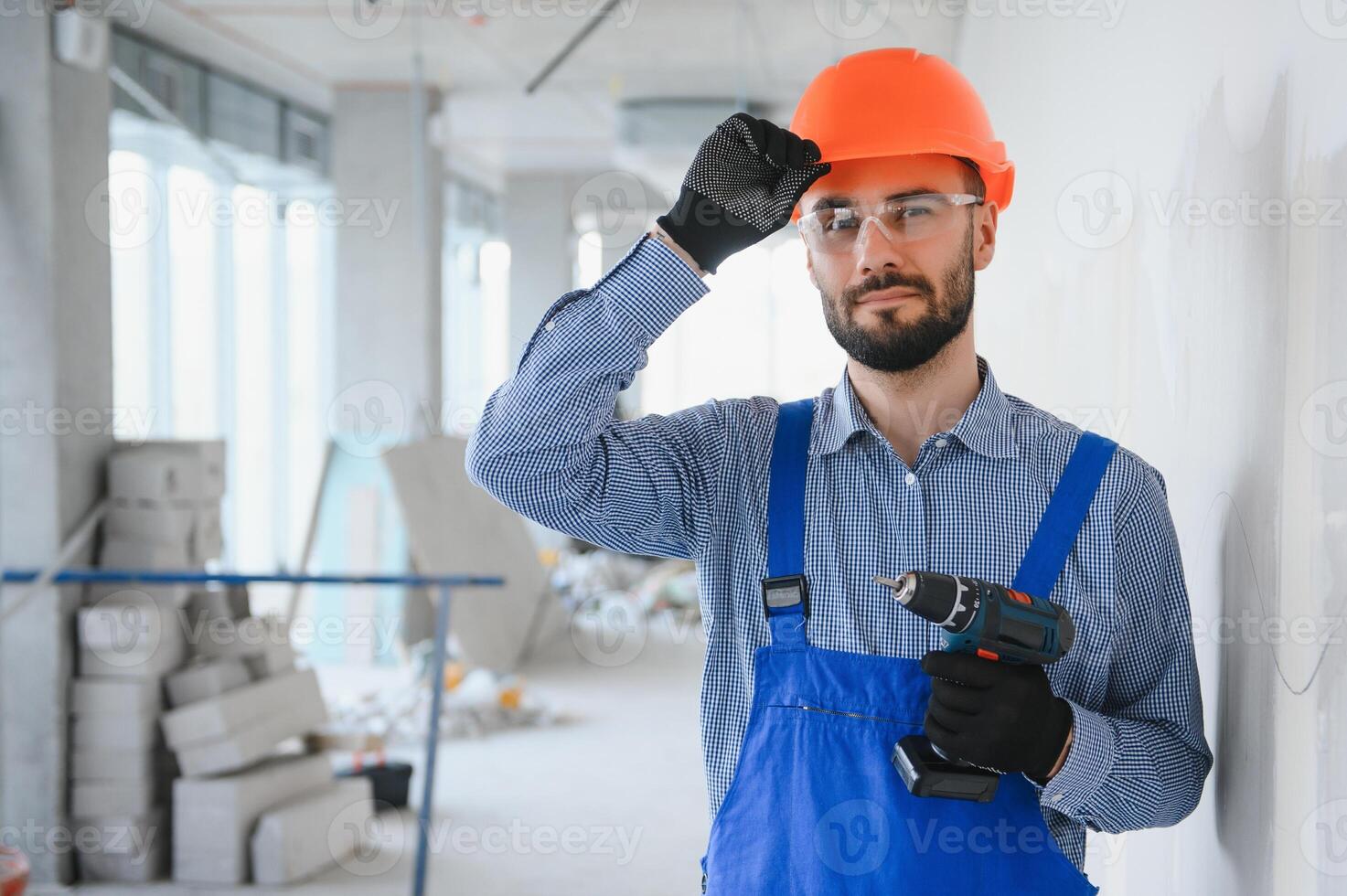 ritratto di giovane e laborioso costruttore in posa nel grande incompiuto camera. edificio concetto foto