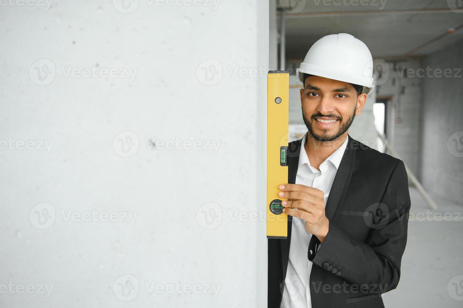 asiatico ingegnere bello uomo o architetto con bianca sicurezza casco nel costruzione luogo. in piedi a moderno edificio costruzione. lavoratore asiatico uomo Lavorando progetto edificio foto