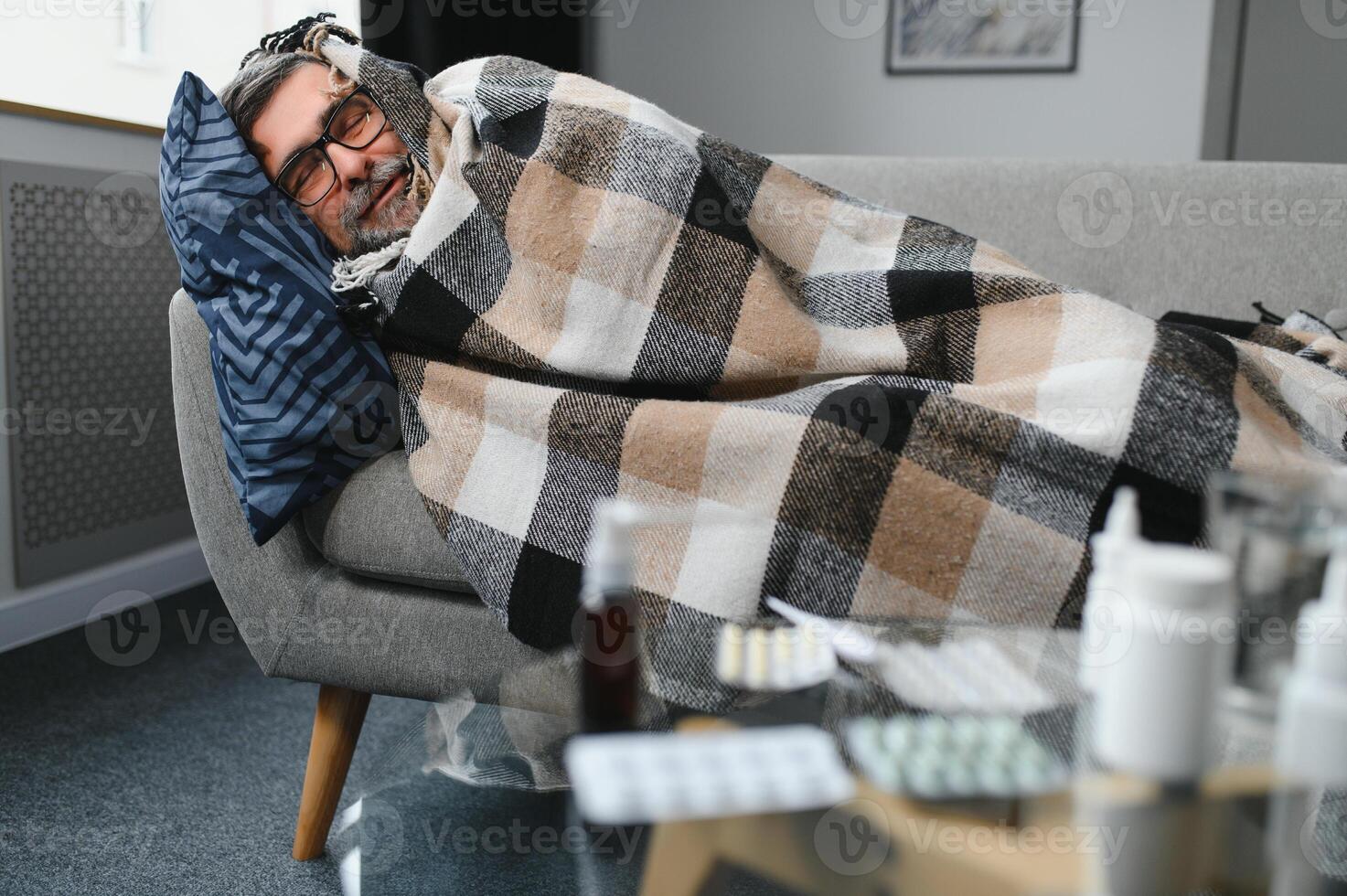 uomo avvolto nel plaid su il divano sensazione malato malattia a casa foto