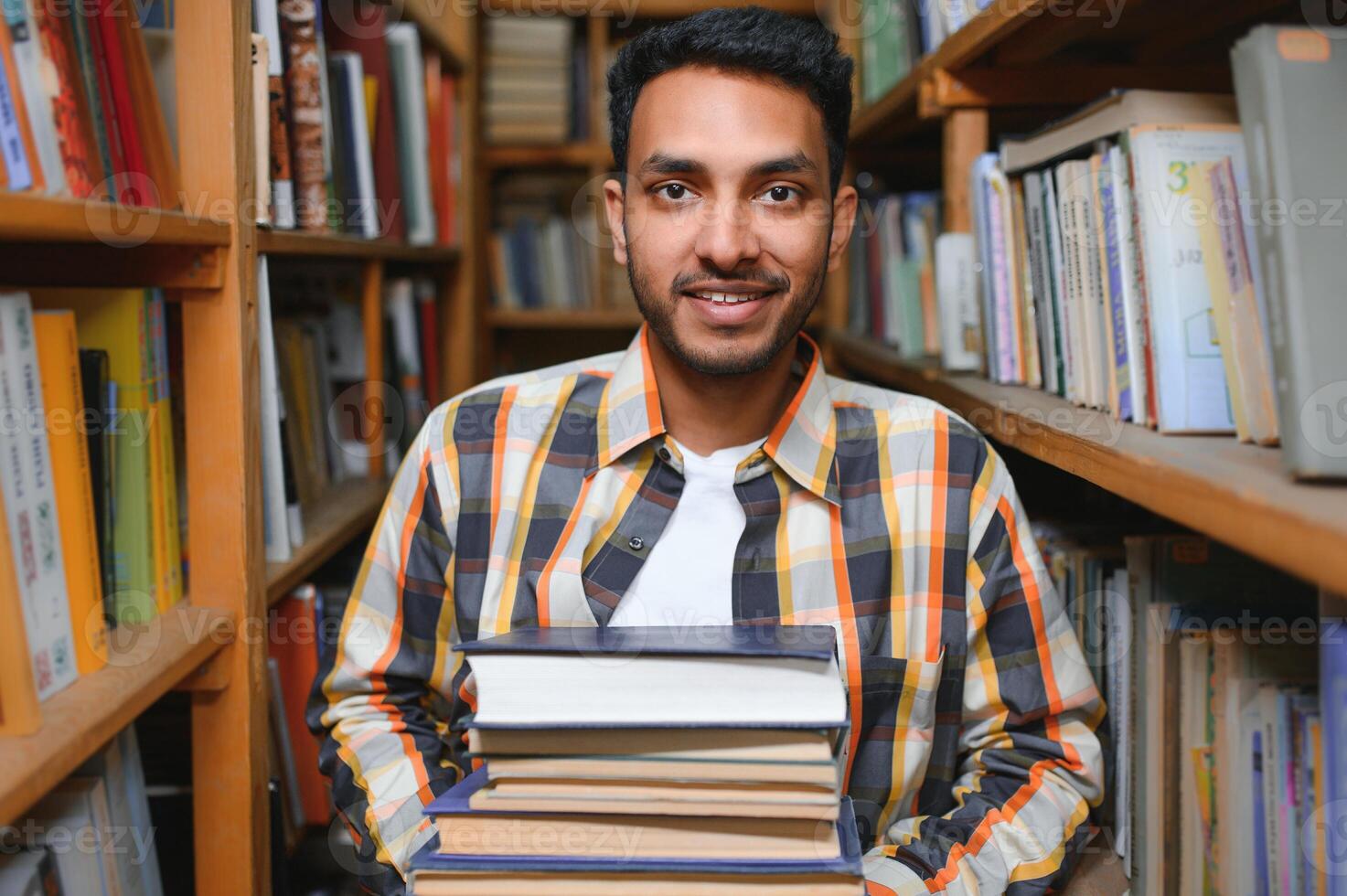 contento inteligente indiano o arabo tipo, misto gara maschio, Università alunno, nel il biblioteca foto