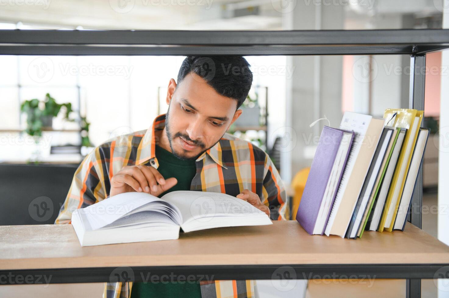 contento indiano maschio alunno a il biblioteca foto