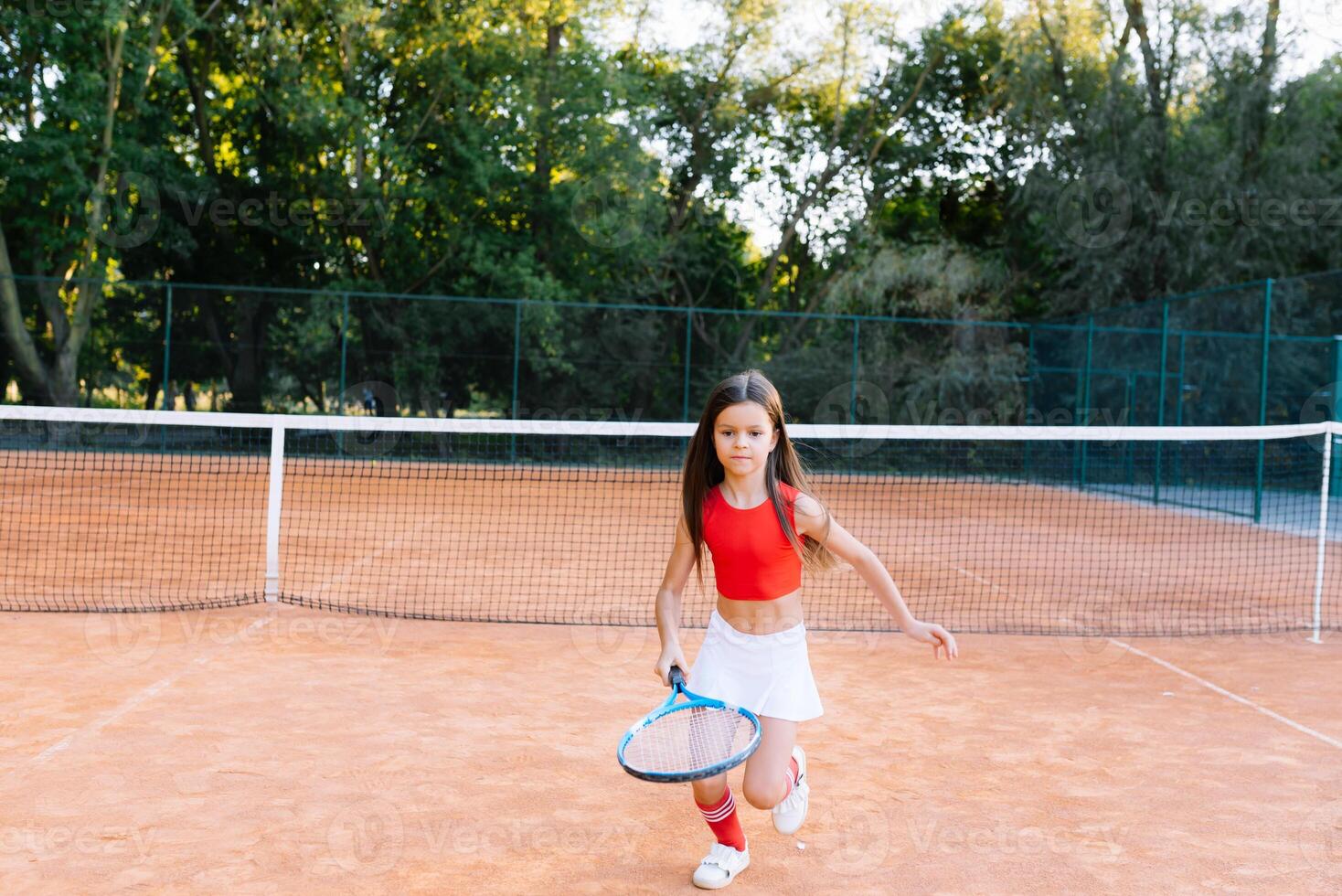 carino poco ragazza giocando badminton all'aperto su caldo e soleggiato estate giorno foto