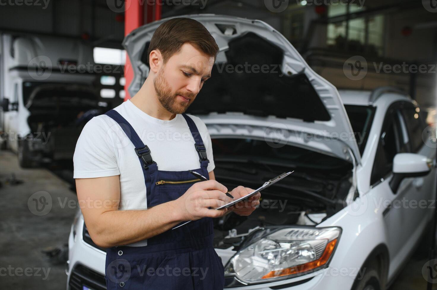 auto meccanico scrittura mentre Tenere appunti vicino macchine foto