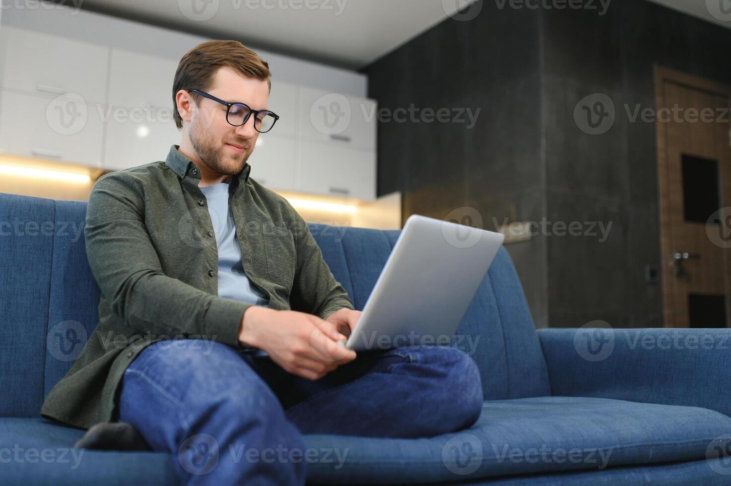 lato Visualizza bello giovane uomo d'affari nel occhiali Lavorando con computer. piacevole contento uomo comunicare nel sociale Rete, ricerca informazione in linea foto