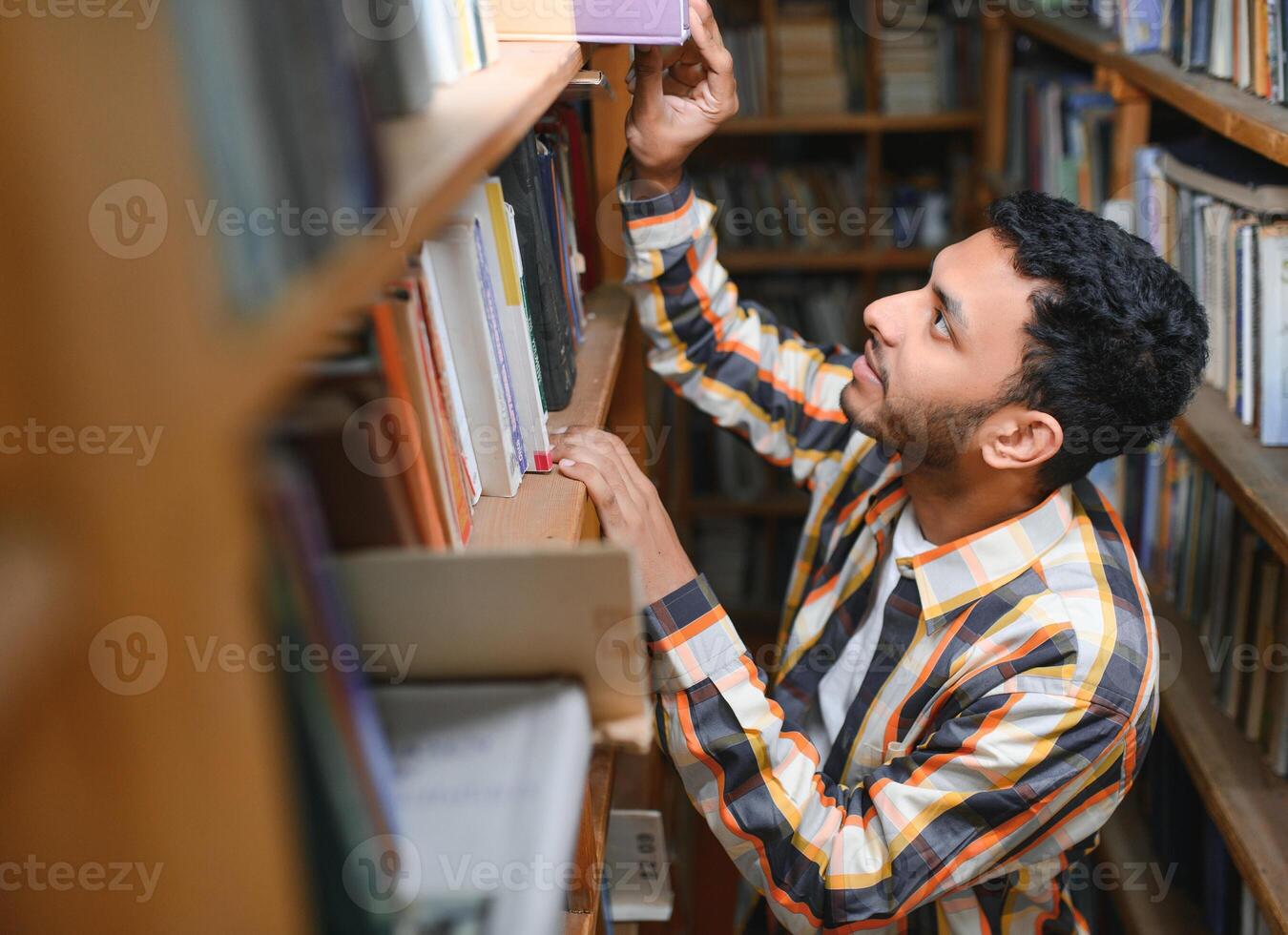 contento inteligente indiano o arabo tipo, misto gara maschio, Università alunno, nel il biblioteca foto