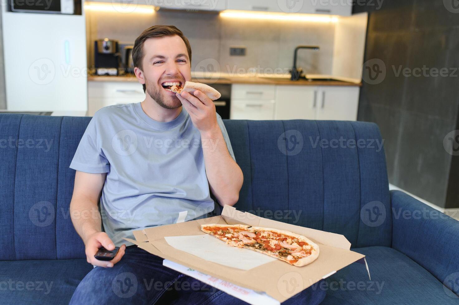 uomo mangiare Pizza avendo un' porta via a casa rilassante riposo foto