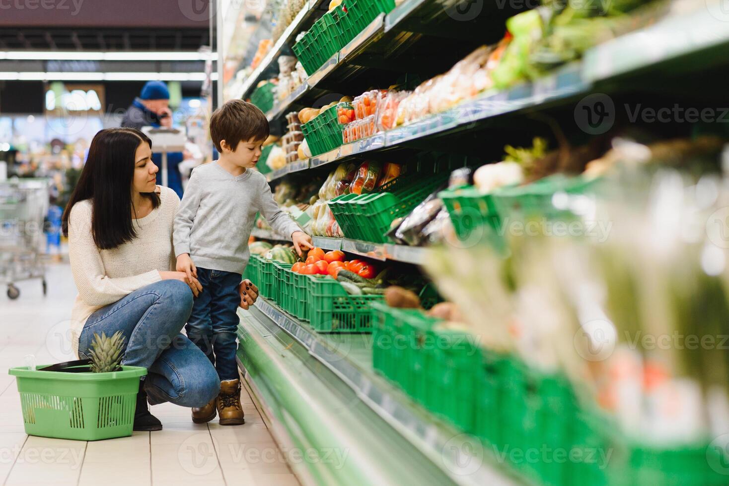 donna e bambino ragazzo durante famiglia shopping con carrello a supermercato foto