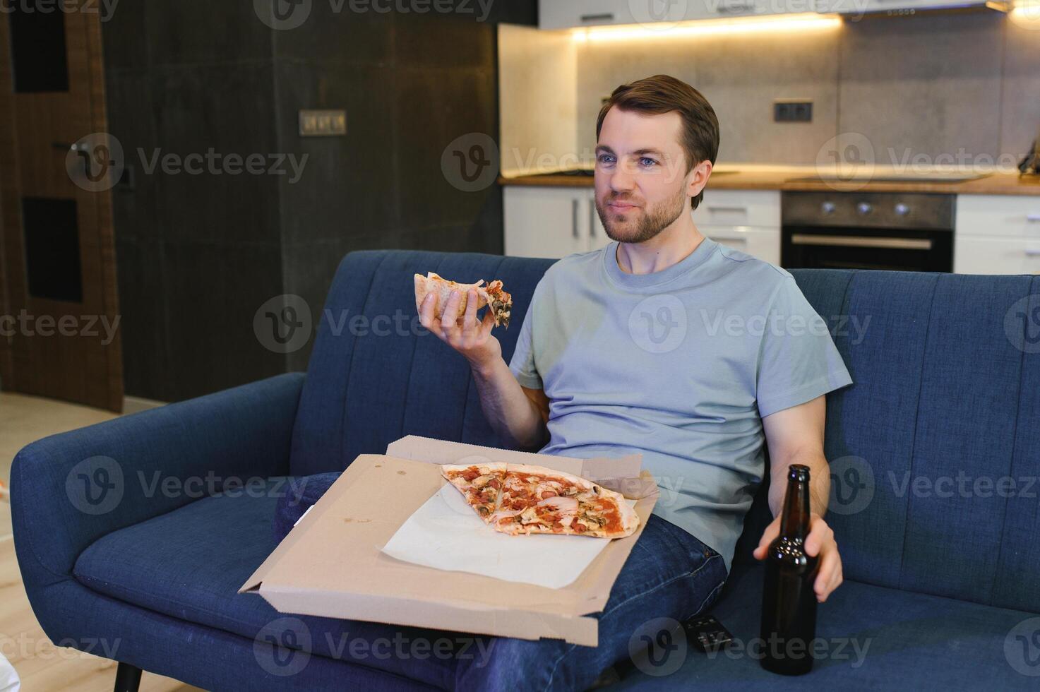 uomo mangiare Pizza avendo un' porta via a casa rilassante riposo foto