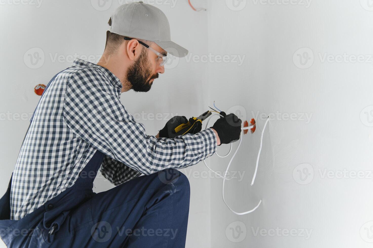 professionale elettricista Lavorando su un' casa elettrico sistema, lui è installazione un' parete presa di corrente foto