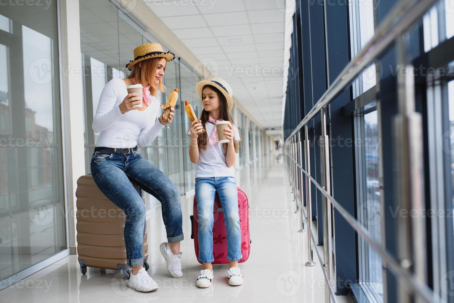 mamma con sua figlia a aeroporto terminale con valigie mangiare veloce cibo foto