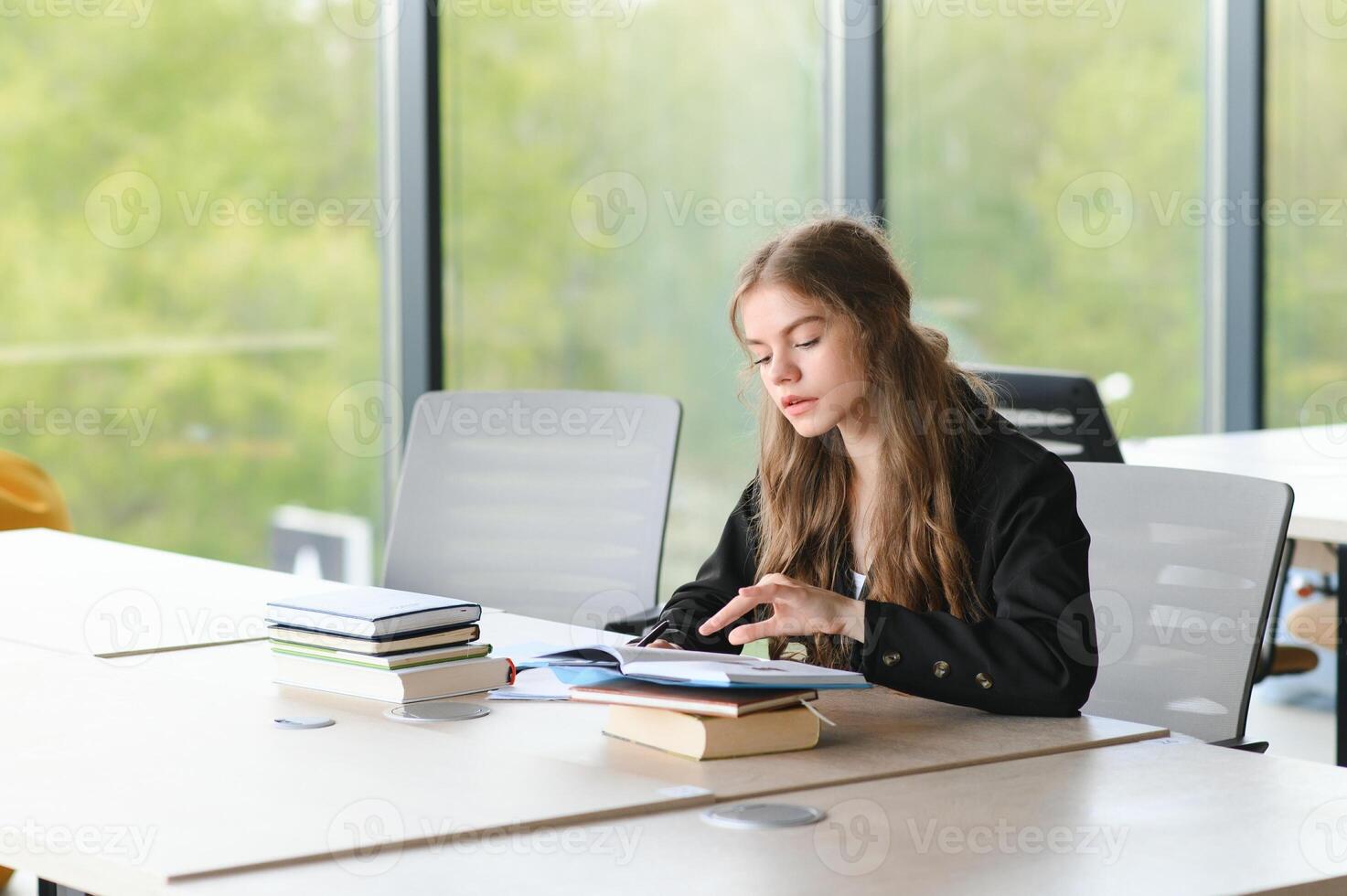 adolescente ragazza studiando con manuale scrittura saggio apprendimento nel aula. foto