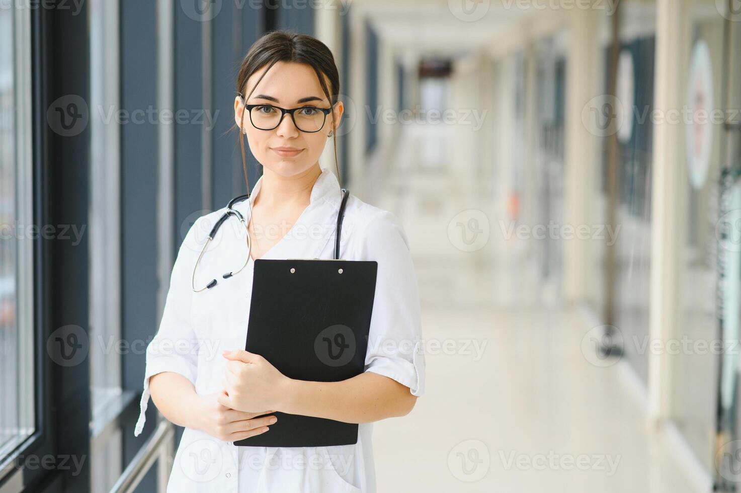 contento giovane femmina medico indossare uniforme, bianca medico cappotto, stetoscopio. ritratto di bellissimo femmina medico, terapista, infermiera. foto