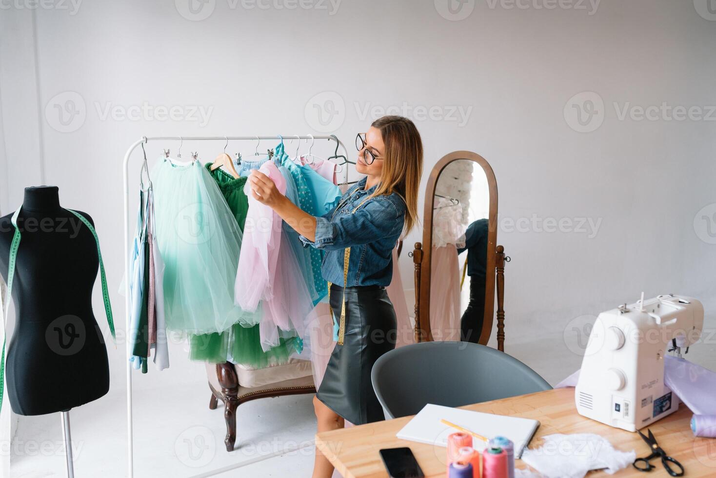 Lavorando su nuovo collezione. nuovo ordine. femmina moda progettista lavori su il nuovo Abiti nel il officina. foto