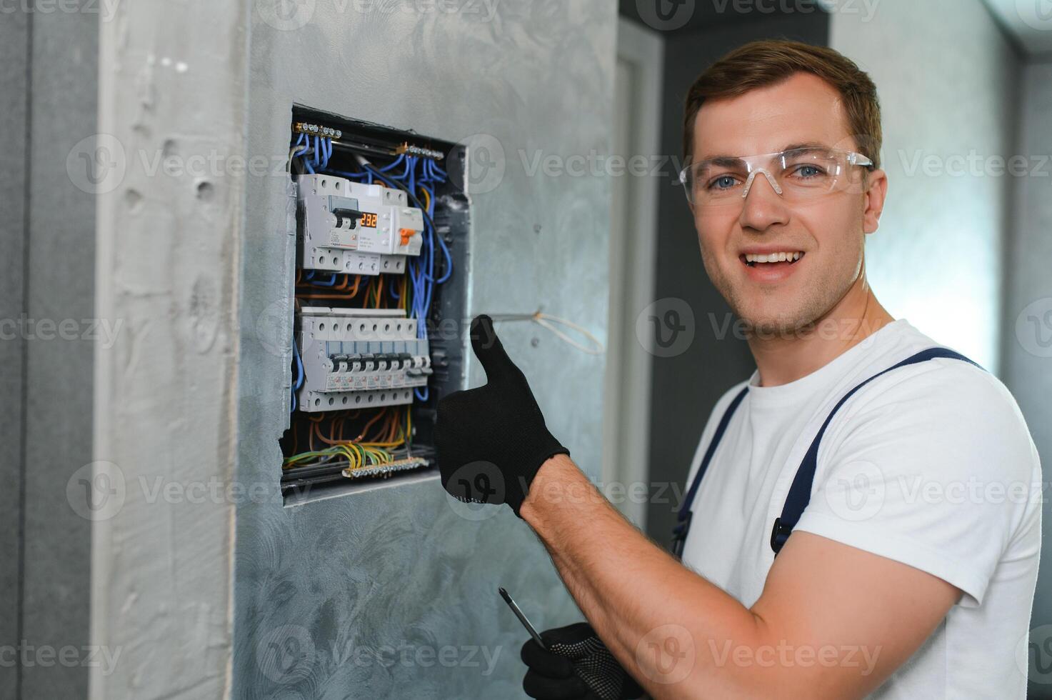elettricista lavoratore a opera su un elettrico pannello foto