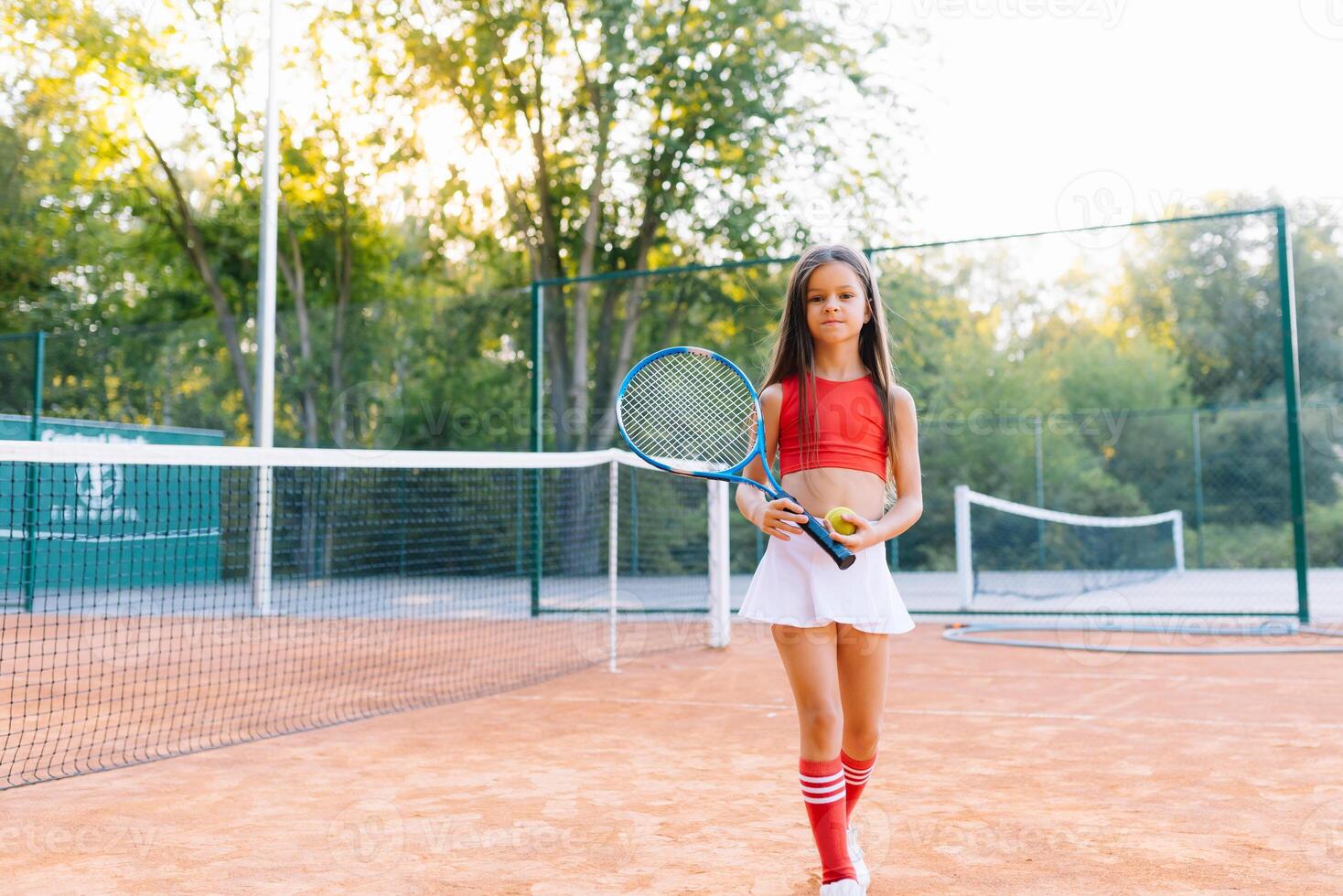 carino poco ragazza giocando badminton all'aperto su caldo e soleggiato estate giorno foto