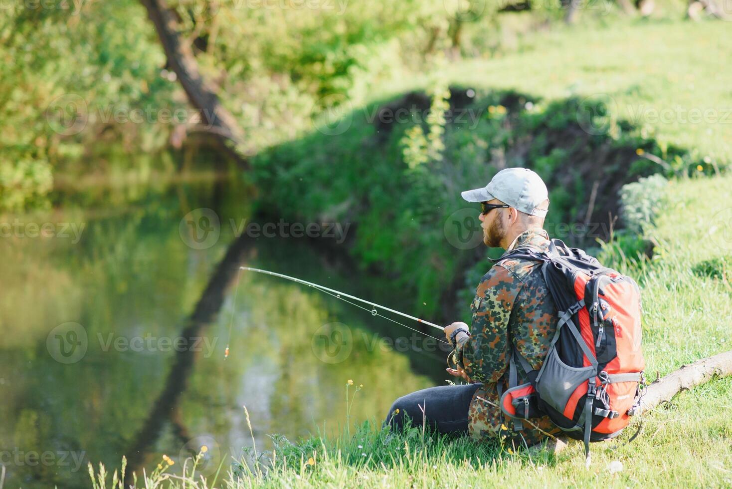 giovane pescatore Pesci vicino il fiume. il concetto di all'aperto attività e pesca foto