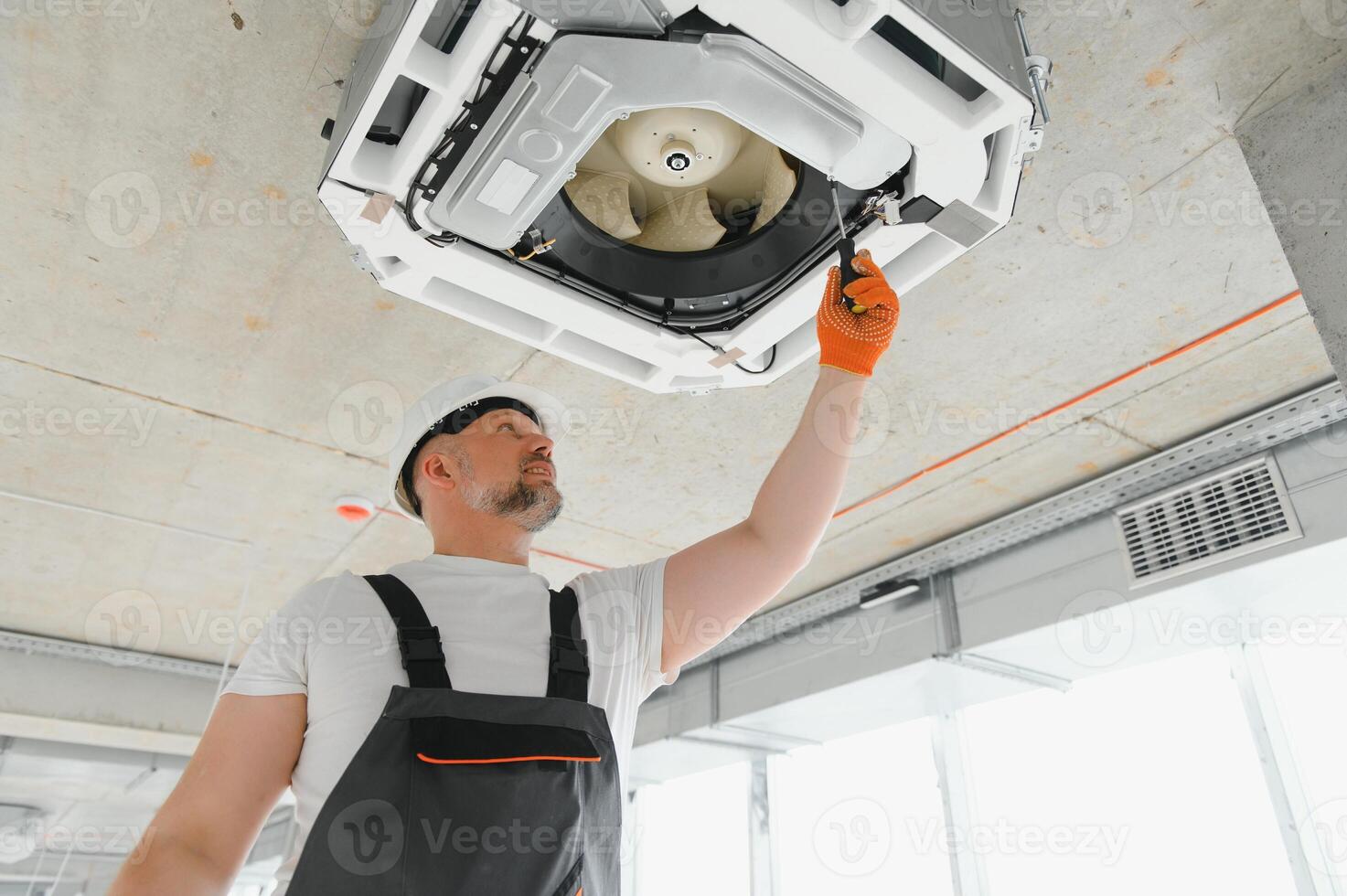 lavoratore riparazione soffitto aria condizionata unità foto