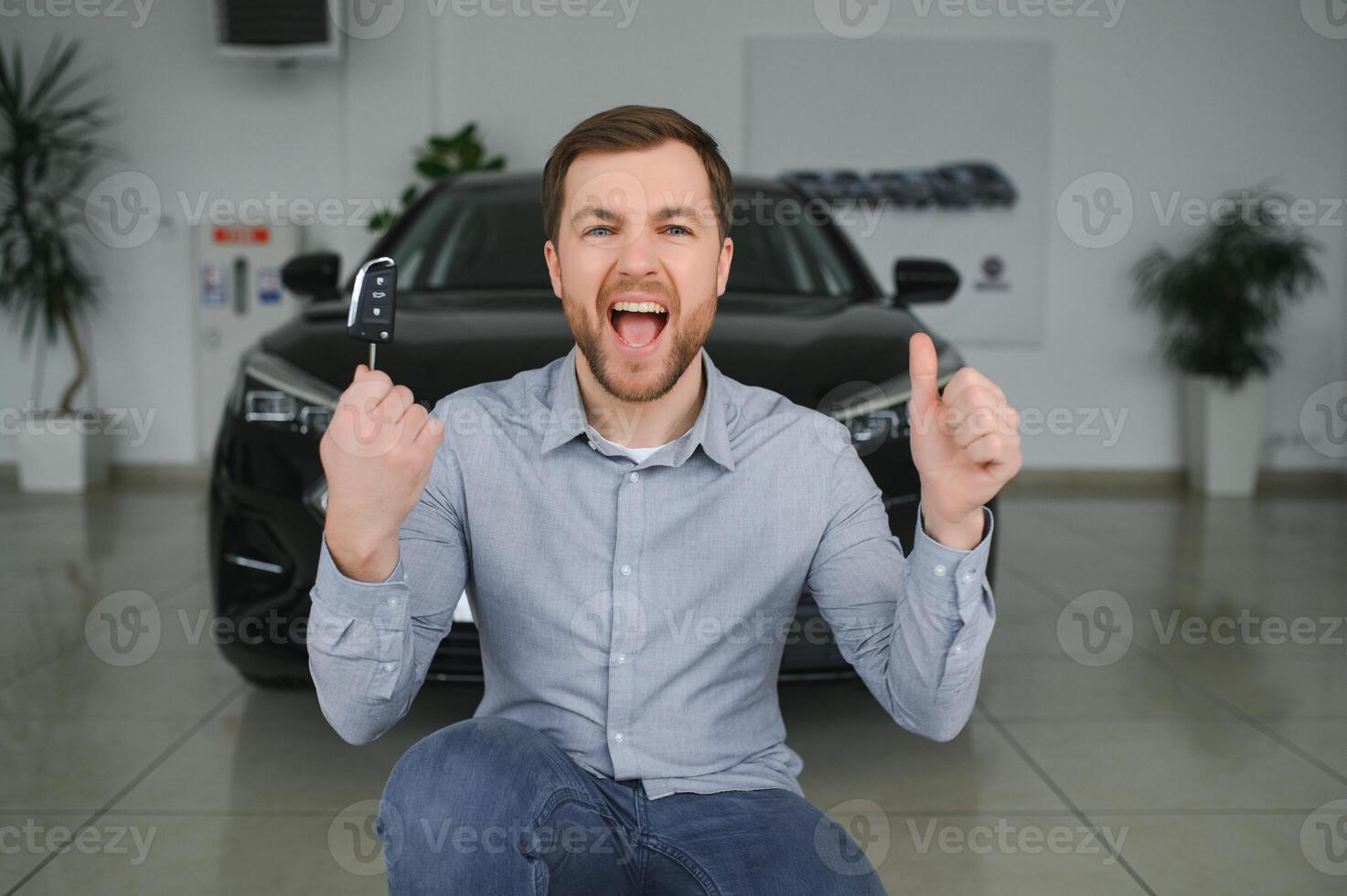 visitare auto concessionaria. bello barbuto uomo è accarezzando il suo nuovo auto e sorridente. foto