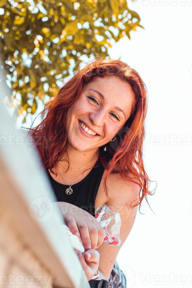 ragazza rossa felice in un parco, primo piano foto