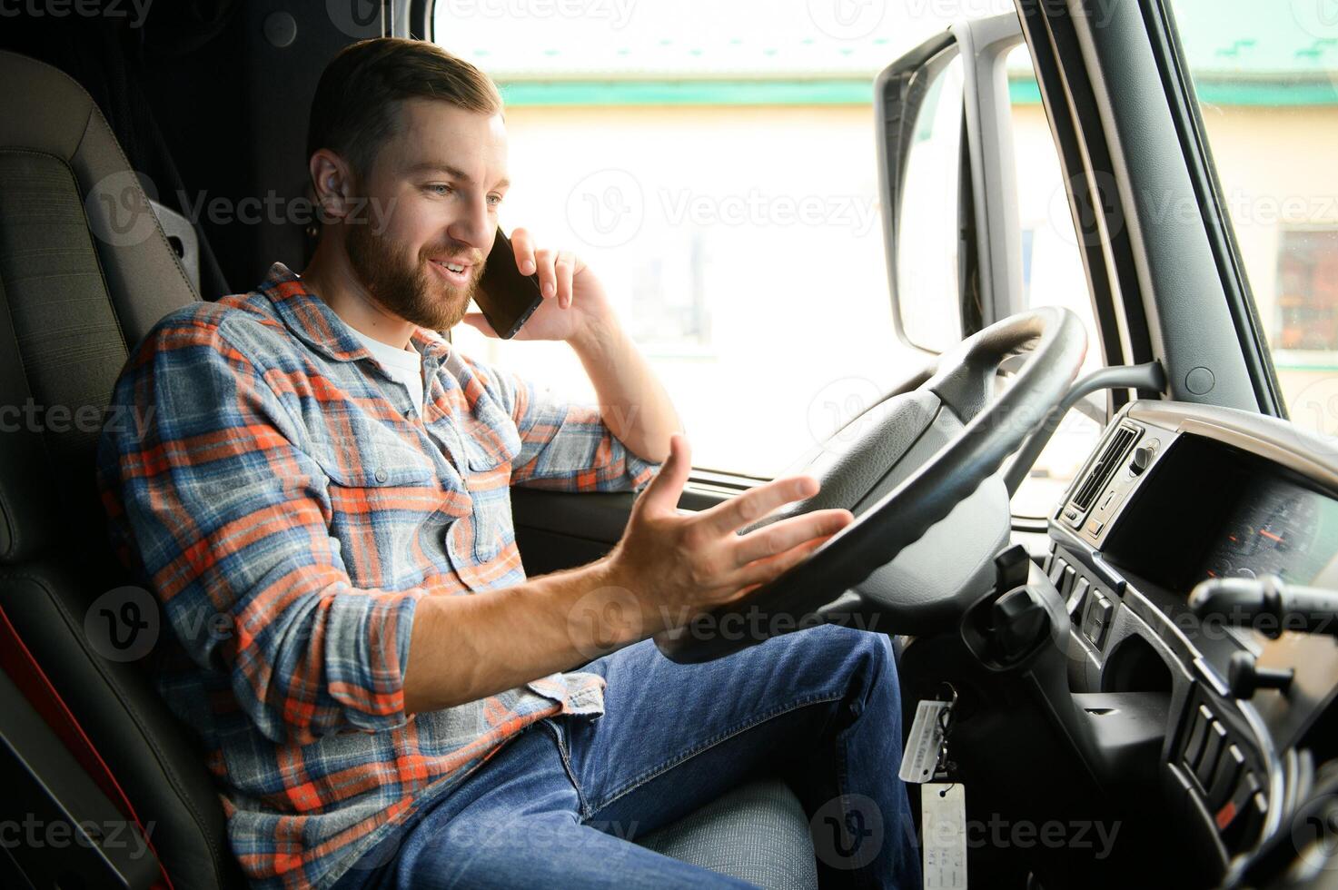 giovane professionale autista comunicare al di sopra di mobile Telefono mentre guida un' camion. foto