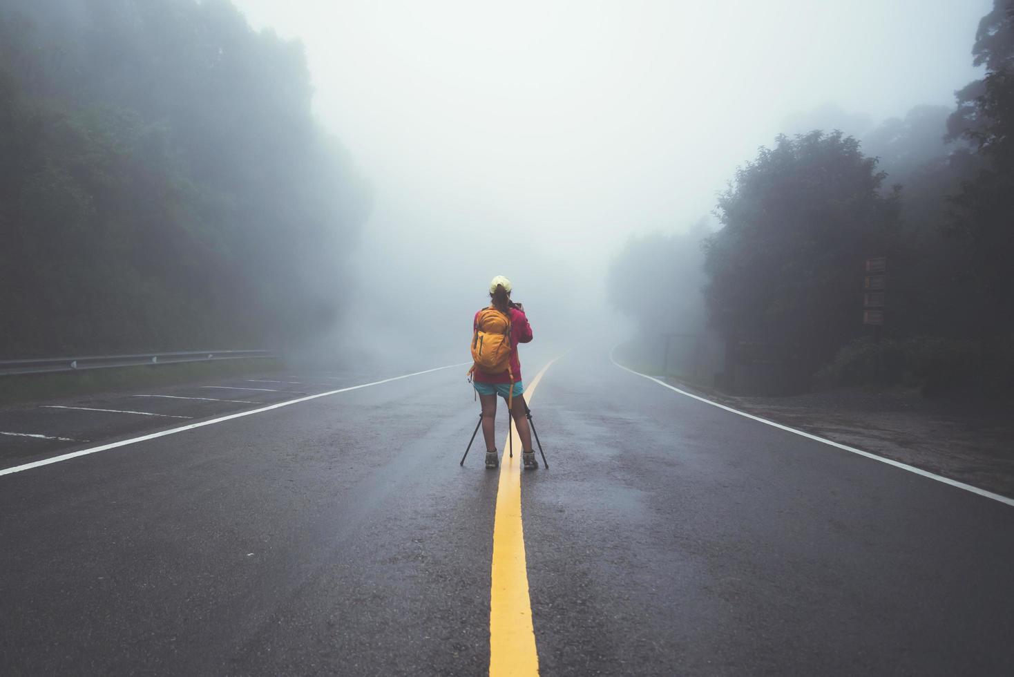 le donne asiatiche viaggiano nella natura. camminare sul percorso stradale. viaggiare felicemente nella natura della fotografia. in mezzo alla nebbia piovosa. nella stagione delle piogge a chiangmai in thailandia. foto