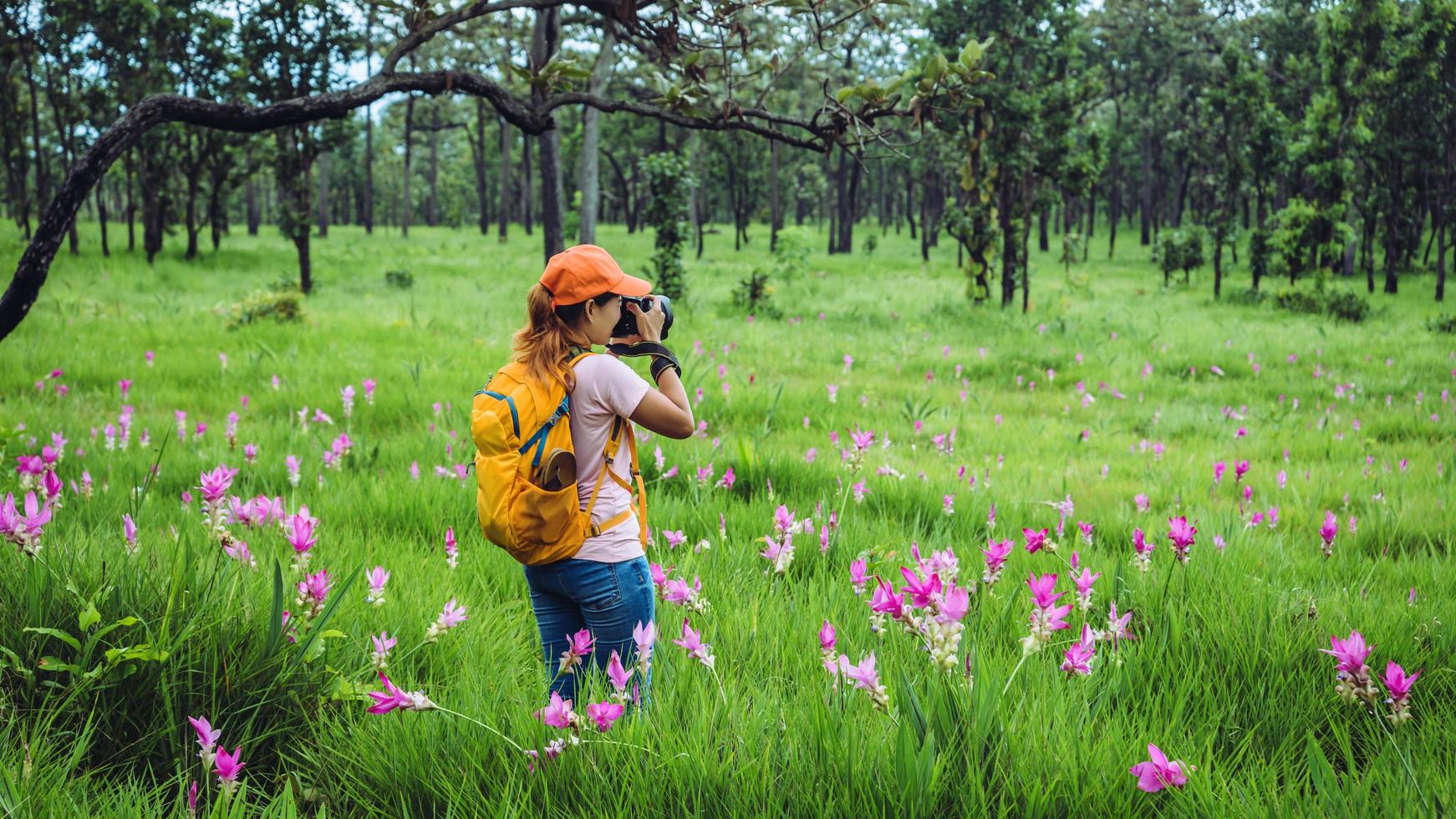 natura di viaggio donna asiatica. viaggiare rilassati. fotografia campo di fiori di cetriolo sessilis. foto