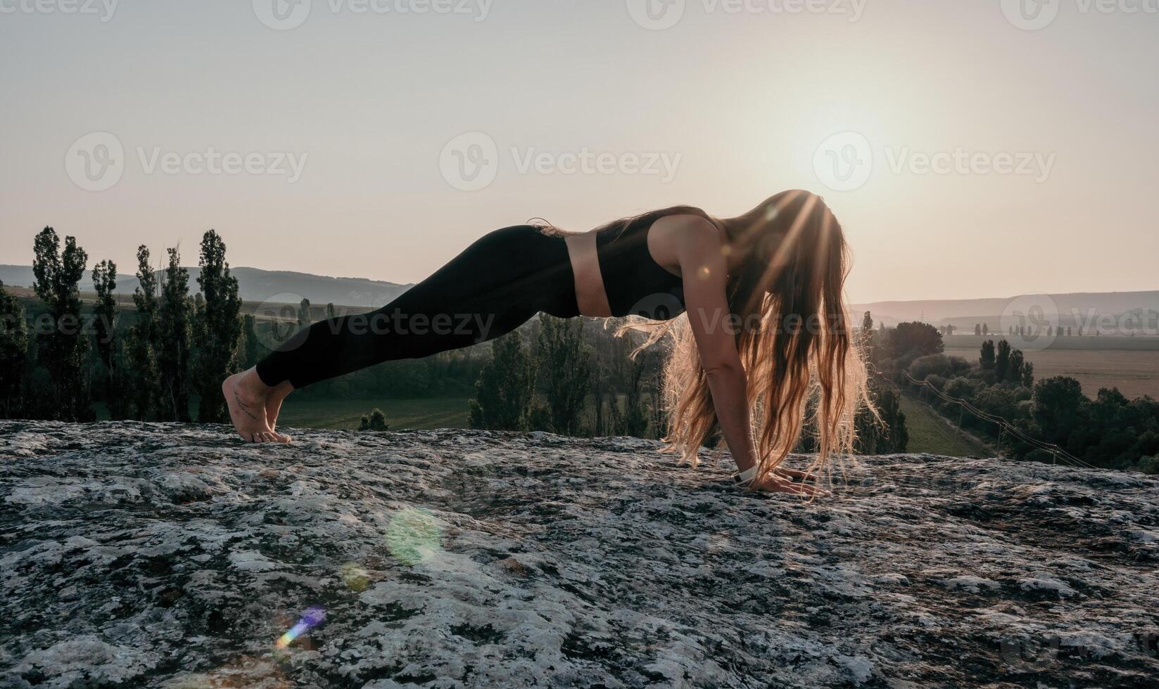 fitness donna. bene guardare mezzo anziano donna con lungo capelli, fitness istruttore nel ghette e cime fare allungamento e pilates su il roccia vicino foresta. femmina fitness yoga routine concetto. foto