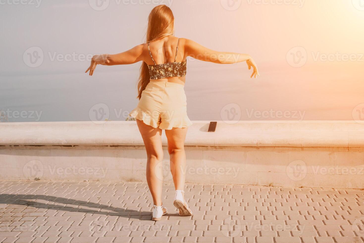 donna estate danza. silhouette di un' contento donna chi balli, gira e solleva sua mani per il cielo. un' giocoso giovane donna gode sua contento momento danza nel il raggi di il d'oro sole. foto