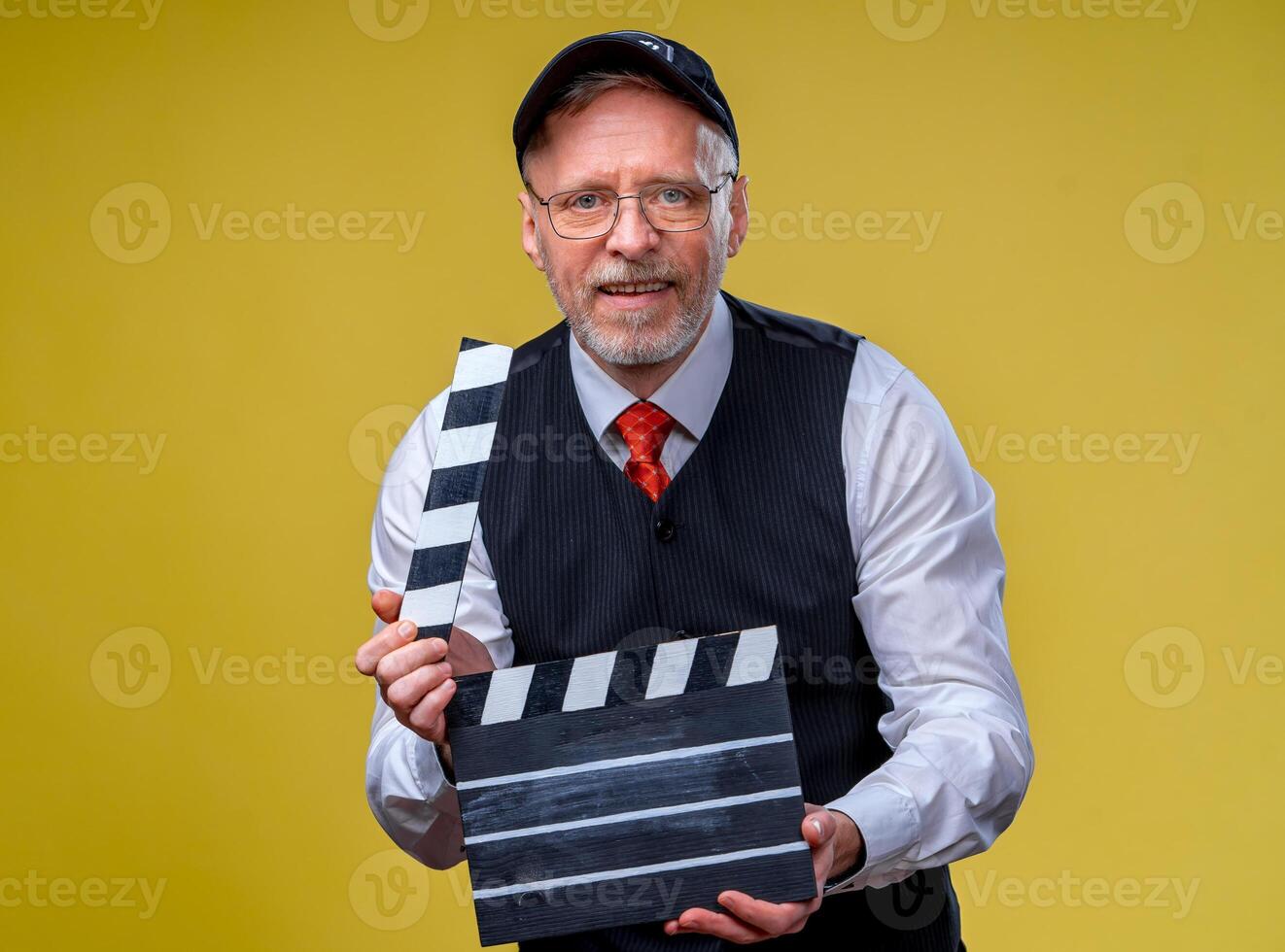 anziano uomo detiene film falda vicino su. film dirigere. film produzione. umano emozioni. uomo con film falda mentre le riprese foto