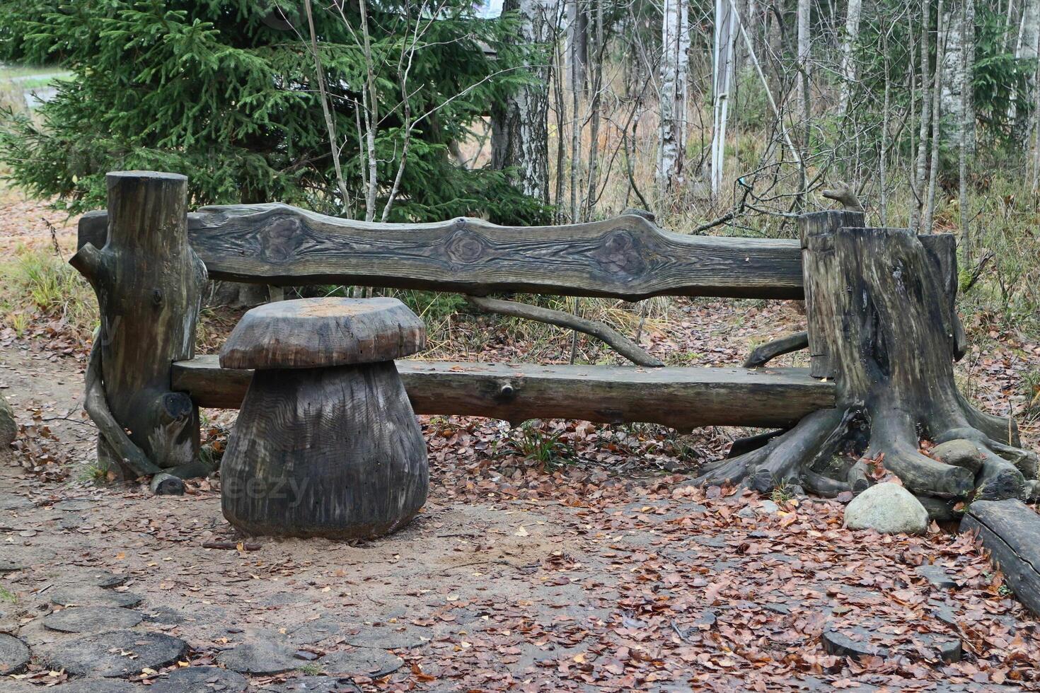 panchina e tavolo fungo per rilassante e picnic nel natura, panchina fatto di vecchio monconi e registri, Esposto alle intemperie legna struttura, autunno nel il foresta foto