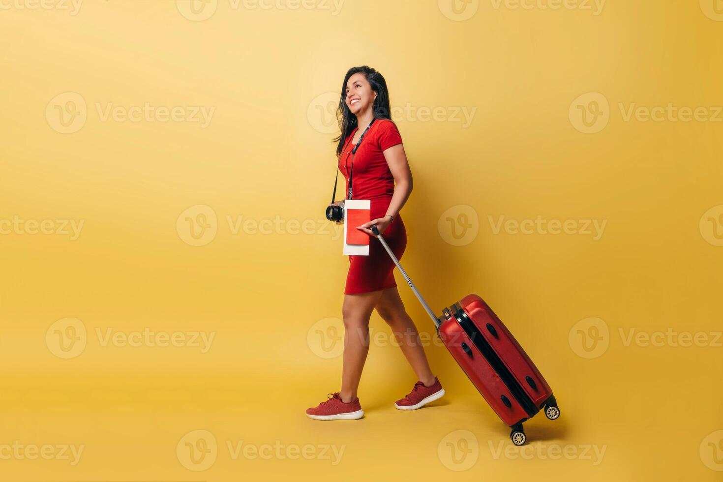 pieno lunghezza di un' latinx donna a piedi hold un' valigia e passaporto guardare lontano. foto