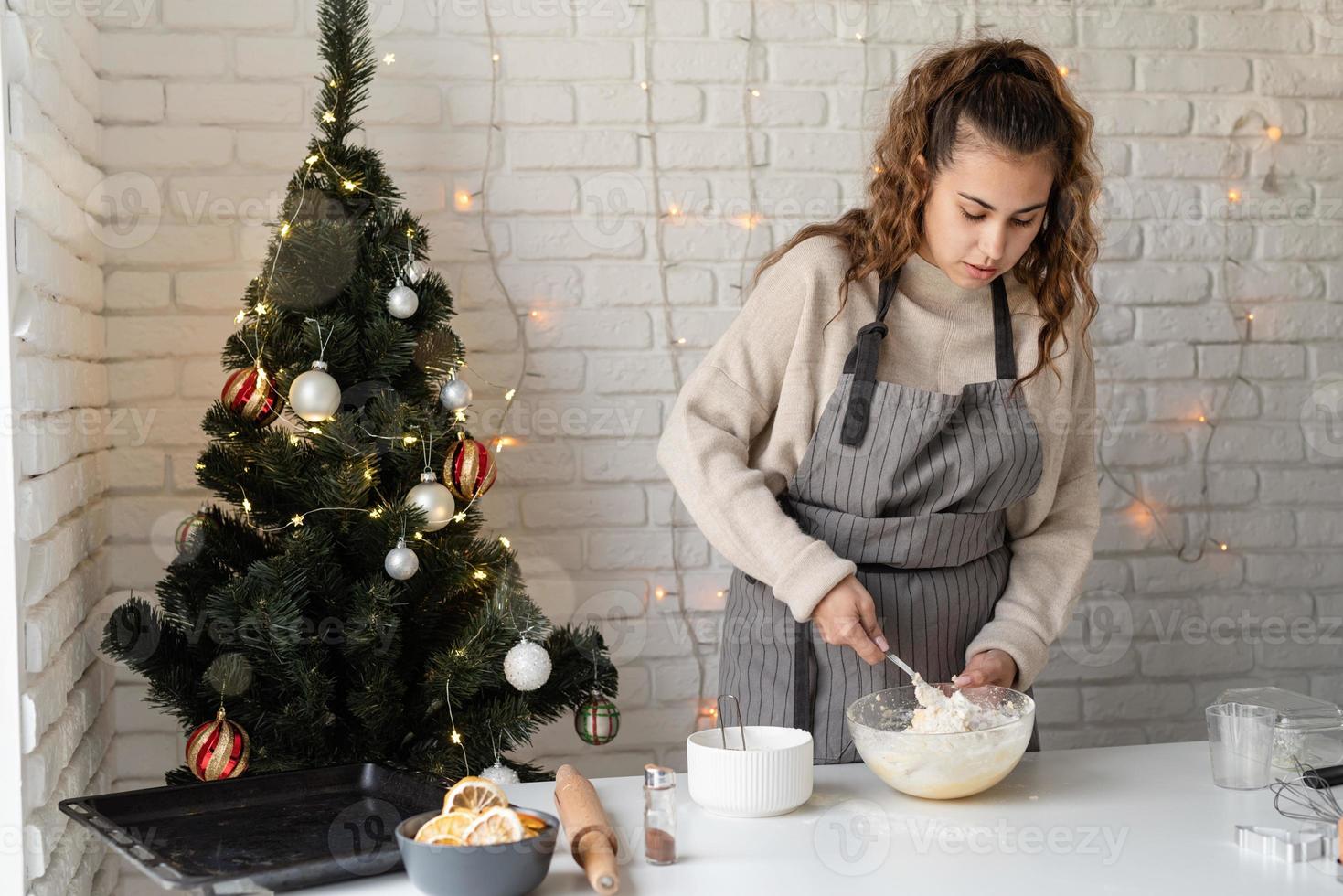 donna sorridente in cucina a cuocere i biscotti di natale foto