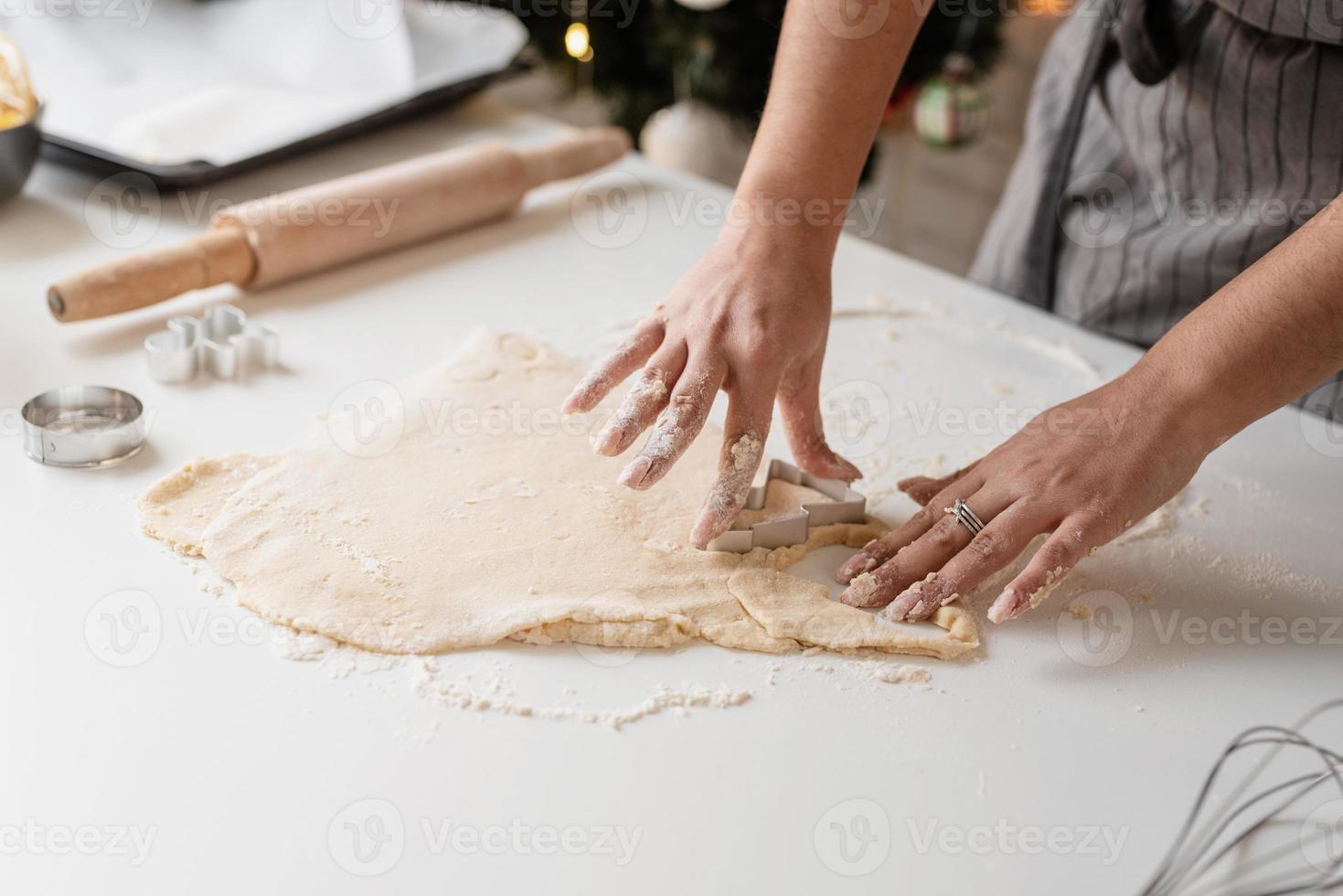 donna sorridente in cucina a cuocere i biscotti di natale foto