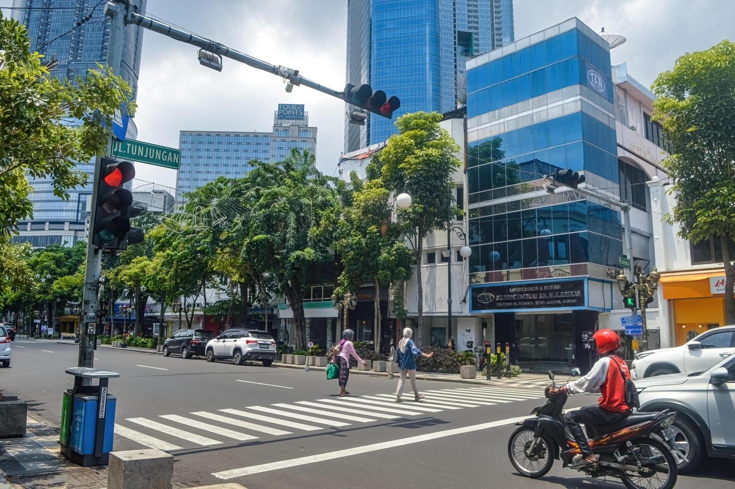 persone chi siamo attraversamento un' zebra attraversamento attrezzata con traffico luci su un urbano strada, Indonesia, 2 marzo 2024. foto