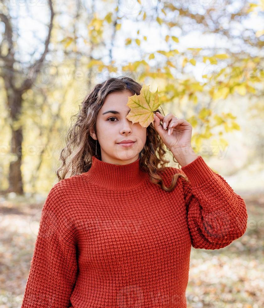 giovane donna felice che cammina nella foresta autunnale foto