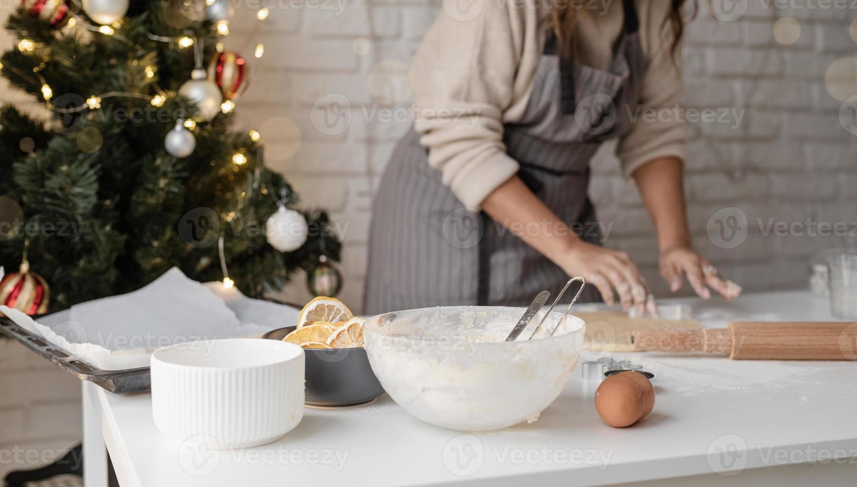 donna sorridente in cucina a cuocere i biscotti di natale foto