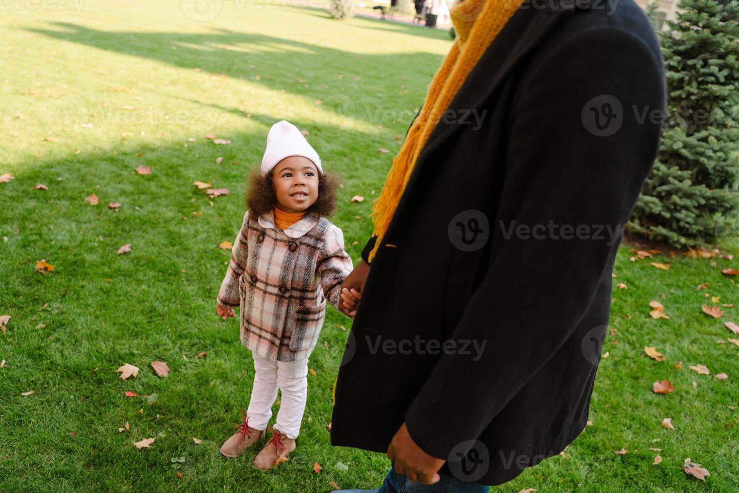 nonno nero che parla con sua nipote durante una passeggiata all'aperto foto