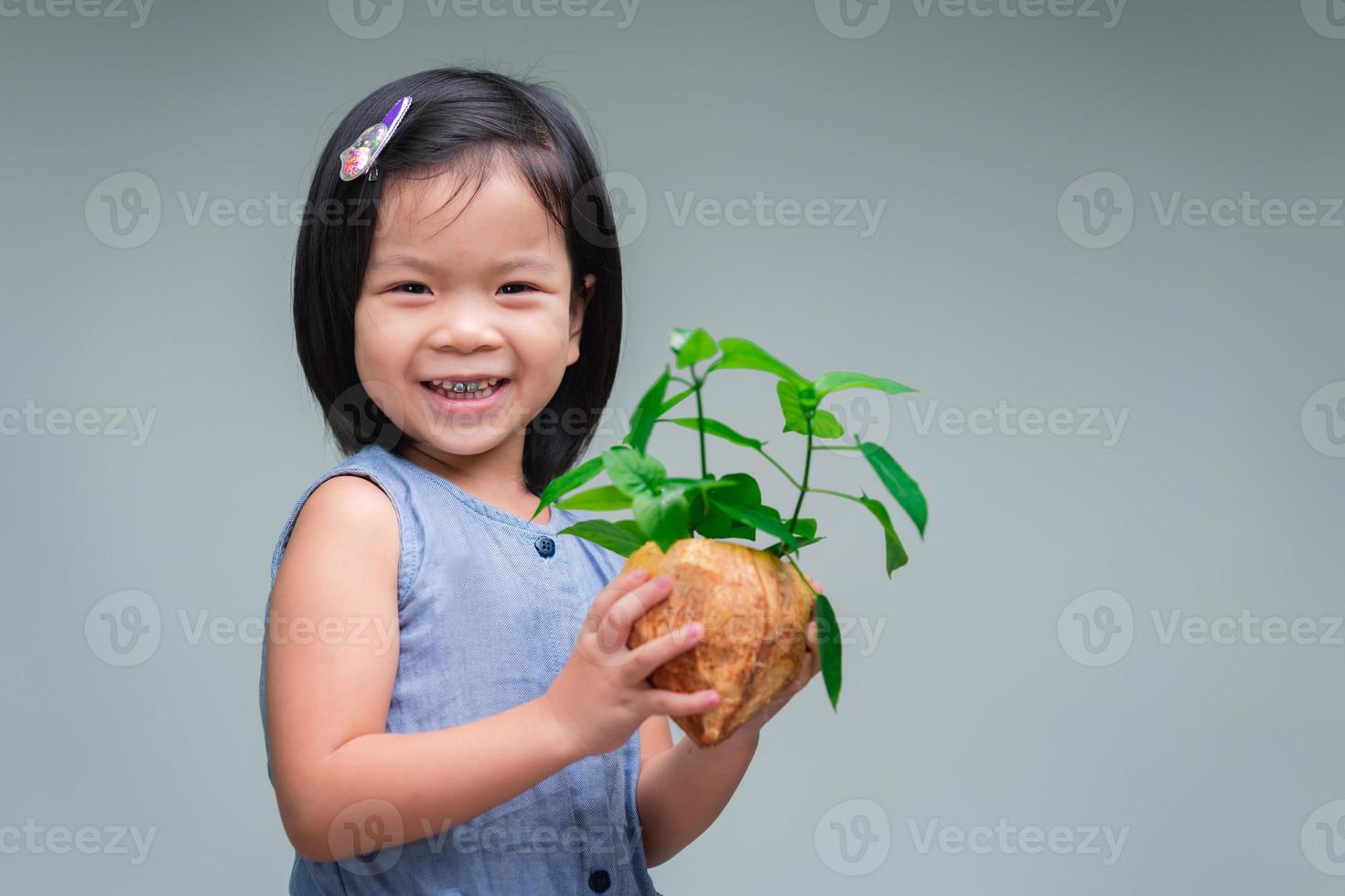 il bambino tiene la pianta che è stata piantata in vaso. sfondo isolato. dolce bambino sorridente. concetto di salvare il mondo. giornata di conservazione della natura. giorno dell'ambiente. foto