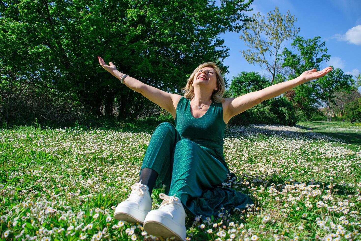 maturo contento donna nel il nel erba con margherite. menopausa e La madre di giorno concetto foto