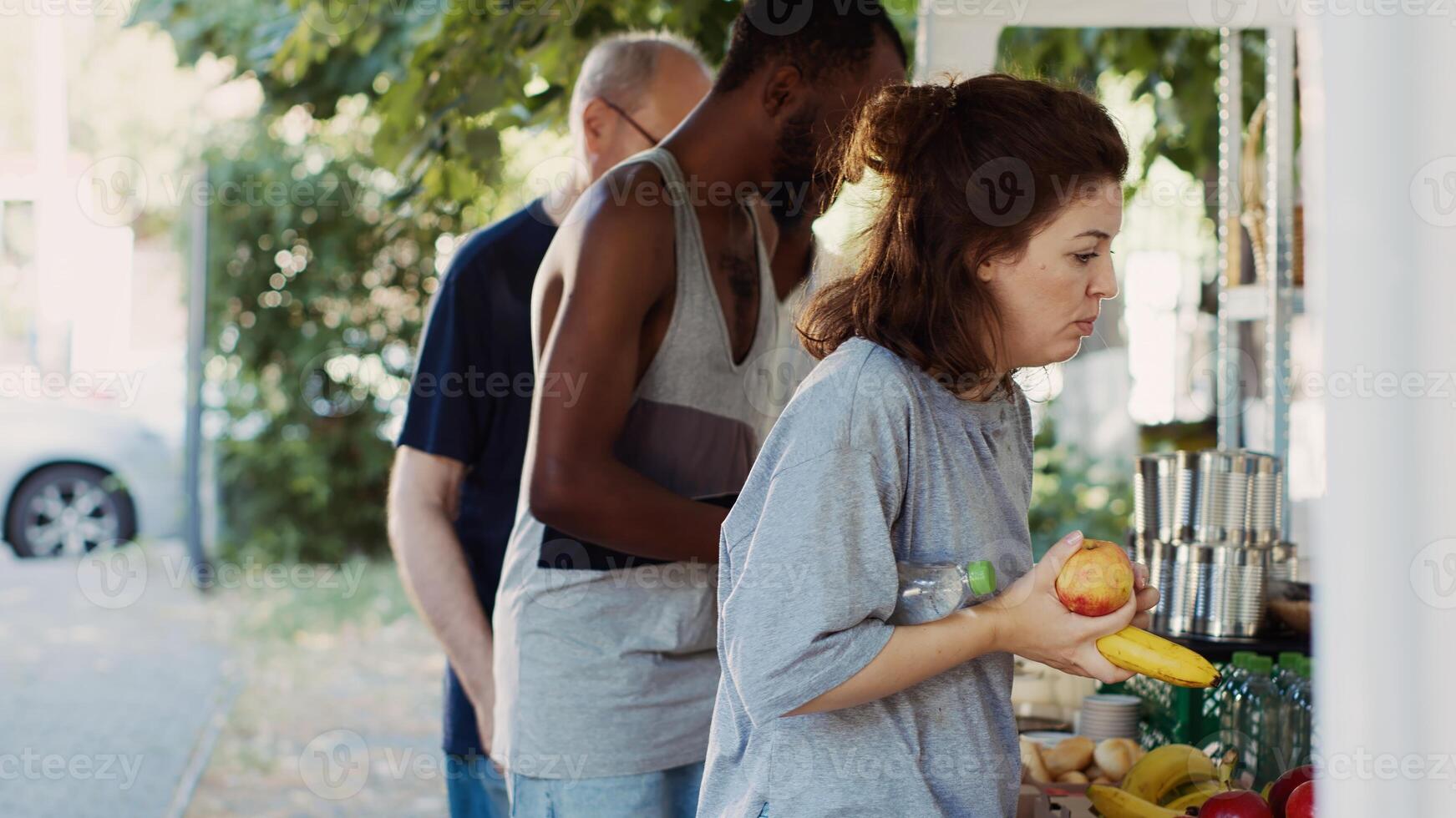 coda di povero e senza casa persone ricevente caldo pasti e necessità a partire dal caritatevole individui. squadra di volontari distribuzione donato cibo elementi per il Di meno privilegiato a senza scopo di lucro cibo viaggio. foto