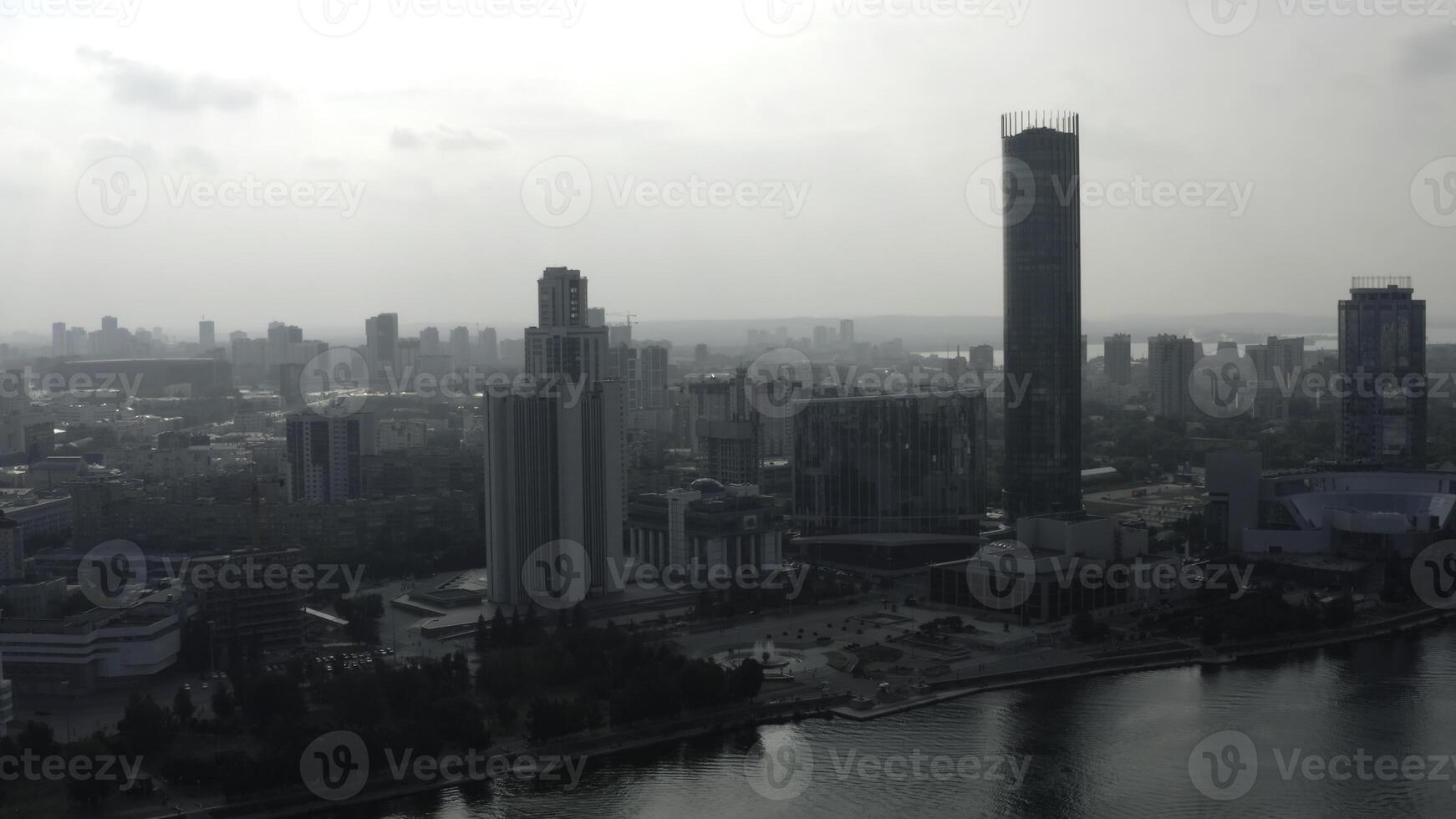 superiore Visualizza di moderno grigio città nel nuvoloso tempo atmosferico. azione filmato. grigio nuvoloso città con fiume e nebbia. nuvoloso giorno sospeso al di sopra di moderno città foto