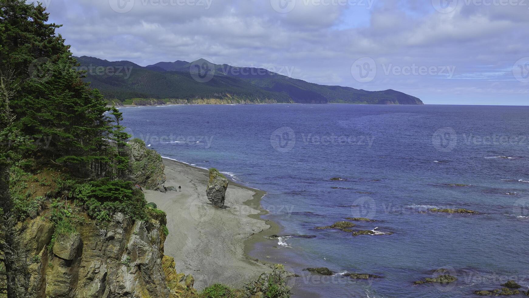 bellissimo Visualizza di piegare di costa con rocce su soleggiato giorno. clip. paesaggio di roccioso costa con verde montagne e foresta. bellissimo spiaggia con rocce e blu mare su soleggiato giorno foto