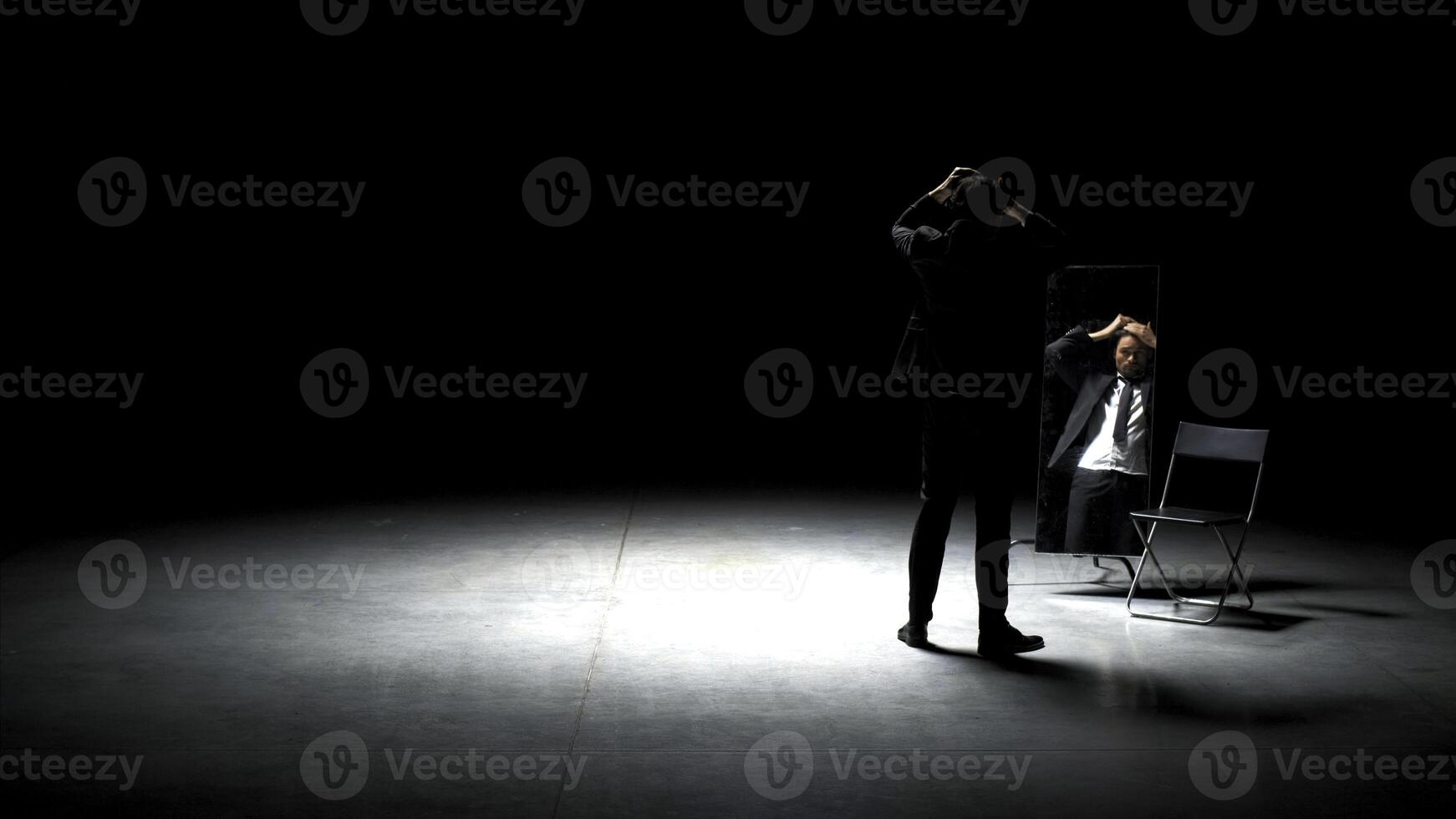 uomo nel completo da uomo pettini il suo capelli. azione filmato. bello uomo pettini il suo capelli nel davanti di specchio. uomo nel completo da uomo pettini il suo capelli su Teatro palcoscenico foto