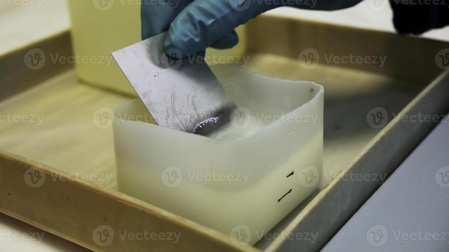 concetto di laboratorio ricerca. clip. vicino su di mani nel guanti mettendo magro metallo piatto in chimico liquido sostanza. foto