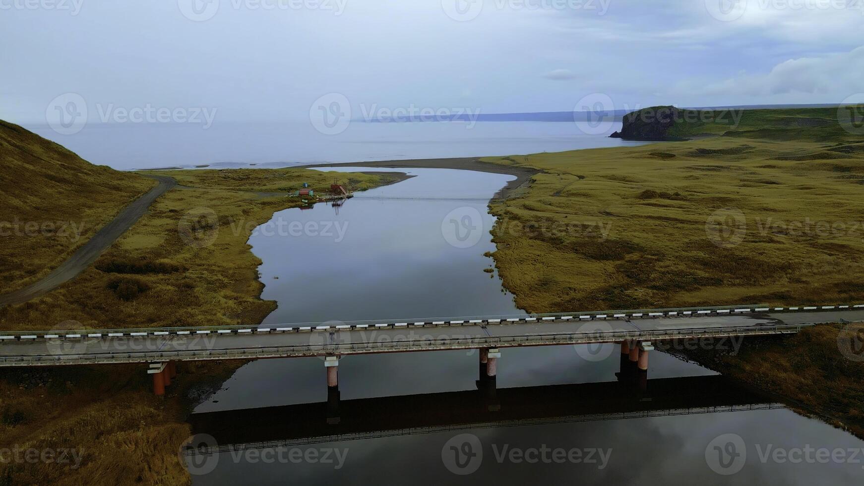 aereo Visualizza di bellissima natura un' ponte fra il fiume sponde. clip. rurale paesaggio con d'oro agricolo i campi in giro e il mare costa. foto