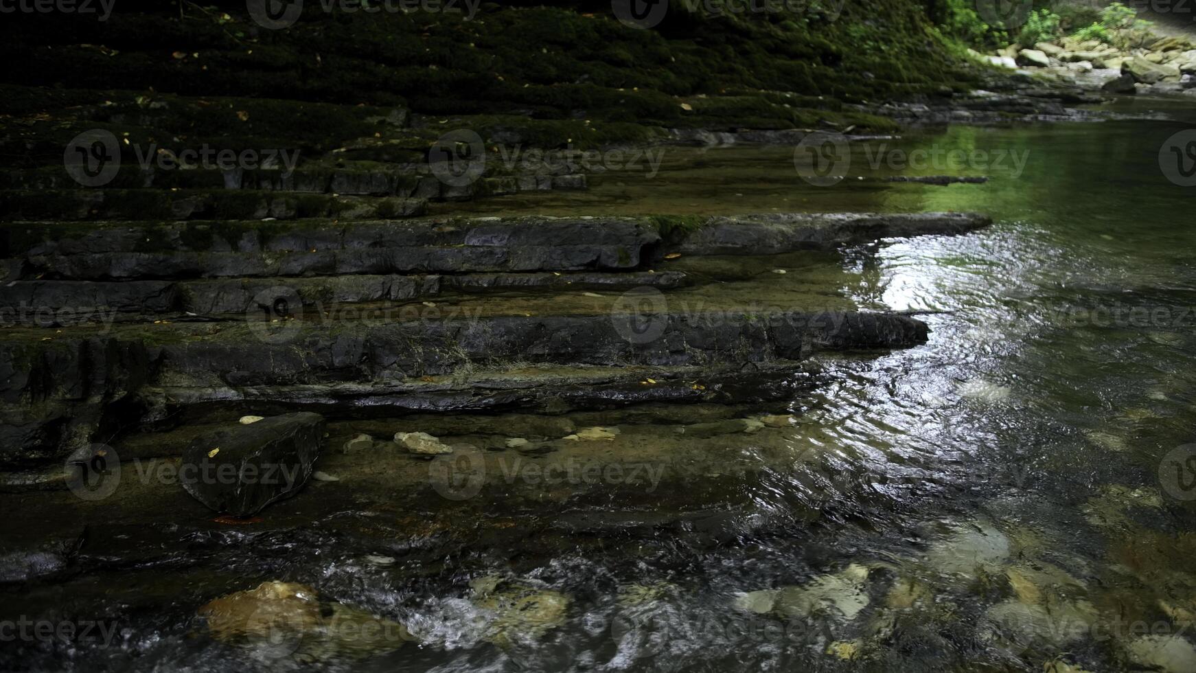 chiaro ruscello in esecuzione attraverso pietra massi. creativo. calma fiume fluente su pietra parte inferiore nel lento movimento. foto