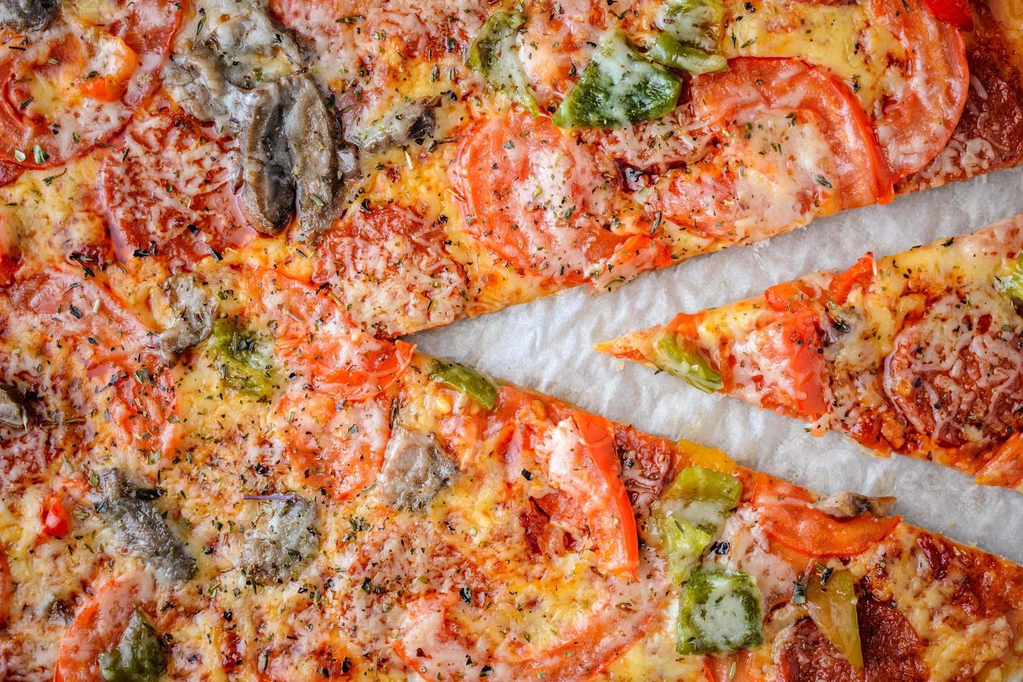 la pizza con salame, pomodori, peperoni e funghi è la vista dall'alto. foto