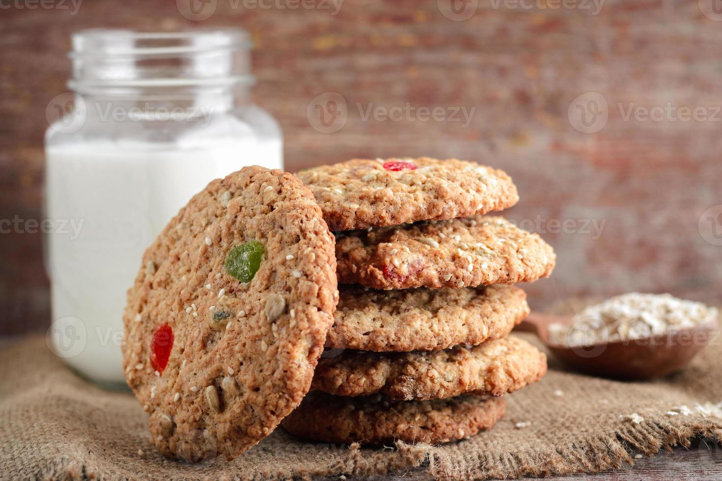 biscotti di avena fatti in casa e latte di vetro su uno sfondo di legno foto