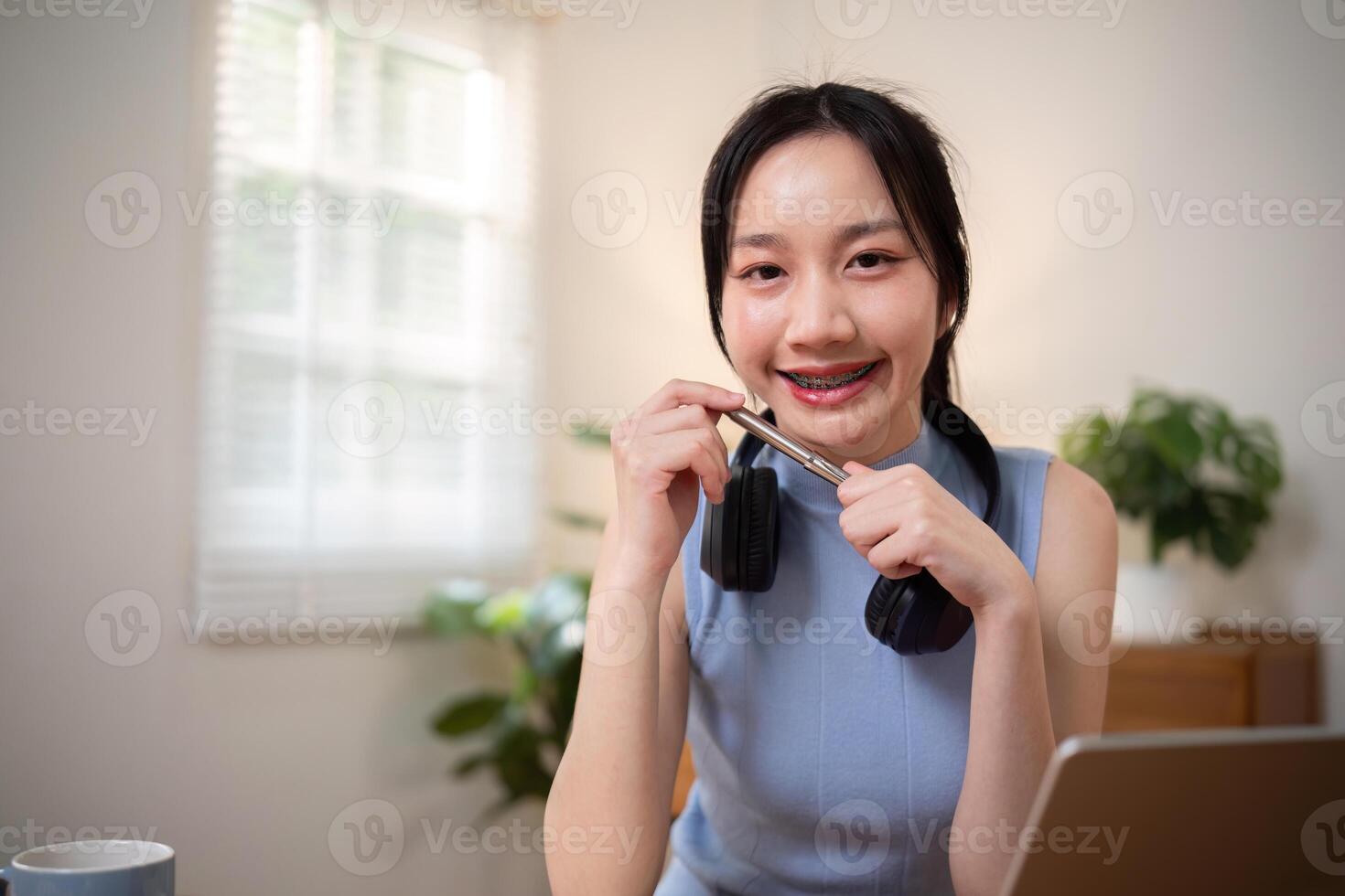 contento giovane donna asiatico nel cuffie e computer portatile, ragazza alunno parlando di video conferenza chiamata, in linea formazione foto